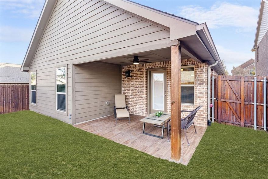Beautiful single-story brick home accented with stone details, ideally located in the Fossil Creek at Westridge community in McKinney. A landscaped front yard welcomes you to a covered brick porch and a wood front door with frosted glass detailing, complete with a Ring doorbell camera. Upon entry, engineered wood floors extend throughout the home, complemented by abundant natural light and a vaulted 9-foot ceiling. The spacious living room features a ceramic wood-burning fireplace with gas starter, creating a cozy focal point, and includes a mounted TV. The pristine galley-style kitchen offers tile flooring, dark walnut cabinets with crown molding, leathered granite countertops, mosaic tile backsplash, an undermount dual sink, bar-height peninsula seating, Frigidaire stainless steel appliances, and an oversized walk-in pantry. The private primary suite features wood floors, serene backyard views from two windows, a vaulted ceiling with fan, and French doors to the en suite bathroom. The primary bath includes a walnut dual vanity with upgraded granite countertops and undermount sinks, updated walnut-framed mirrors, elegant glass light fixtures, a soaking tub, separate tiled shower, private water closet, and a generous walk-in closet with built-in shelving. Two secondary bedrooms feature wood floors, vaulted ceilings with fans, and ample closet space. A full bath offers a walnut vanity with upgraded granite countertop, updated mirror, and tub-shower combo. Additional amenities include upgraded arched interior doors, security system wiring, Honeywell thermostat, upgraded remote sprinkler system, transferable home warranty through May 2027, a 2-car garage, and recent updates including a 2023 roof, fresh paint, mirrors in both bathrooms, and patio tile. Enjoy the covered back porch with new tile flooring and ceiling fan, a spacious fenced yard, and access to the community pool just a one-minute walk away. Zoned for Prosper ISD.