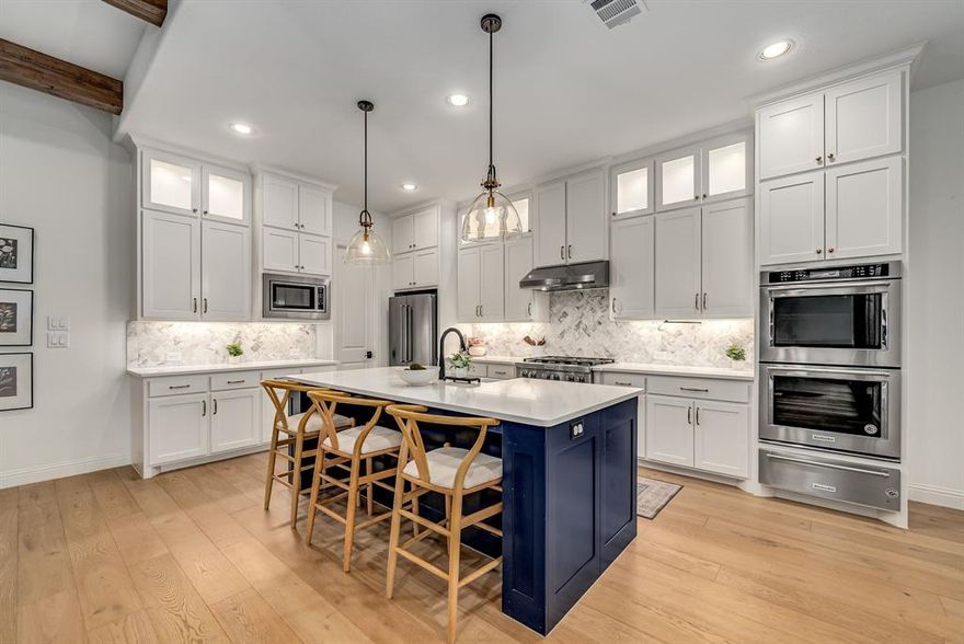 Discover a rare opportunity to own a lakeside retreat in the prestigious, master-planned golf and lakefront community of The Tribute. Designed for both elegance and entertainment, this home welcomes you with an open-concept living area featuring soaring ceilings, custom wood beams, statement lighting, and oversized sliding glass doors that frame a breathtaking private outdoor escape. The gourmet kitchen impresses with an expansive quartz island, premium appliances, and abundant cabinetry. A thoughtful floor plan offers two bedrooms on the main level along with a formal study, dining room, powder bath, and extended covered patio. Upstairs, a spacious game room, fully equipped media room, two additional bedrooms with two full baths, and a serene balcony creating the perfect setting for entertaining or quiet sunset views. Refined finishes continue throughout with plantation shutters, wainscoting accents, upgraded balusters, rich wood flooring, and curated designer touches. Outdoors, the private oasis has been fully transformed with premium turf, a putting green, lush landscaping, built-in grill with keg tap, and a screened-in patio with electronic shades, outdoor fan, and integrated mosquito system for year-round comfort. The 3-car garage with epoxy floors and EV charger adds convenience to style. As a resident of The Tribute, you’ll experience a lifestyle like no other, a golf cart community, two award-winning golf courses, on-site dining, resort-style pools, a planned 800-slip marina, vibrant community events, lakefront trails, playgrounds, and highly rated schools, all just minutes from The Star, Grandscape, and major highways. More than a residence, this is a true lakeside sanctuary blending luxury, community, and resort living.