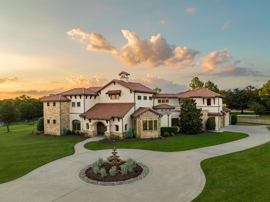 Unforgettable refinement meets timeless beauty in this custom, Tuscan work of art set on over 2 meticulously landscaped acres in the heart of Flower Mound’s prestigious gated community, The Landing at Northshore. A true architectural masterpiece, this breathtaking European estate is a symphony of elegance, craftsmanship, & refined luxury. As if stepping into a story where memories are waiting to be made, picture cozy evenings by the fire, summer pool parties savoring the sunset, & quiet mornings on the balcony overlooking the treed backdrop- life here is nothing short of extraordinary. A spacious covered patio greets you as you enter through the grand iron-accented doors, every detail whispers luxury including the hand-scraped hardwood floors, vaulted ceilings, 3 fireplaces, multiple covered patios & dramatic ironwork accents. Meals are effortlessly elevated in the kitchen with VIKING appliances, 6-burner range with integrated griddle, granite counters, warming drawer, double ovens, expansive island & soft close drawers. A true cinematic escape to the private movie theater featuring a 158-inch acoustically transparent screen, Klipsch surround sound, custom wood entry, two-tiered seating, a half bath & wet bar for elevated movie nights. The home is wired with a whole-house speaker system & boasts custom lighting scenes. Resort-inspired backyard retreat where an expansive covered patio with cool decking overlooks a stunning pool & spa, complete with waterfall, grotto, in-pool tanning platform, & diving-depth section that transforms every summer day into a vacation. Elegant exterior spiral staircase connects the upper balcony to the pool area. Immaculate, oversized 3-car garage makes a statement, featuring gorgeous epoxy flooring, extra-wide doors (two 9-ft, one 10-ft) & walk-in storage closet with built-in shelving- an automotive enthusiast’s dream. 3 beds down & 3 beds up with an expansive game room & second kitchen complete with wine fridge, ice maker, & serving bar