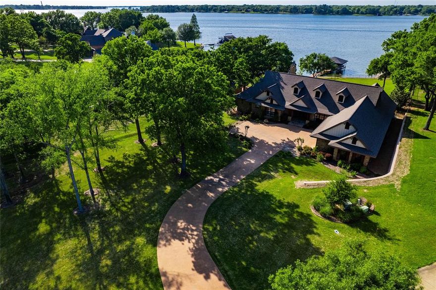 Lakefront Retreat in exclusive gated community. This stunning single-story home, recently renovated to perfection, is offered fully furnished and move in ready. The open-concept living and dining area features soaring vaulted beam ceilings, a dramatic wall of windows and a striking fireplace - ideal for everyday living and upscale entertaining. A sleek wet bar with unique under-counter lighting adds a sophisticated touch. The magazine-worthy primary suite is a true sanctuary, complete with a luxurious bath. Three additional guest en suites provide comfort and privacy for family and friends, while a versatile bonus room off the garage offers the perfect space for a home office, gym or craft room. Step outside to a spacious covered porch overlooking a sparkling saltwater pool and take in breathtaking open water lake views