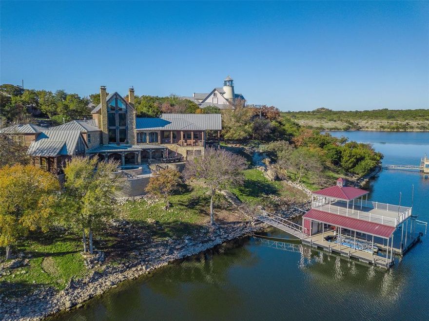 The opportunity to own an iconic lake estate at PK has arrived! This multi-level home sits on a 1.3-acre private, gated waterfront lot in a prime location near Hells Gate. The sloping lot allows for multiple patios that provide ample space for entertaining or relaxing. The swimming pool is an invitation to enjoy leisurely days basking in the sun, while a deep-water dock offers direct lake access for boating. Indoors, the ambiance of a mountain lodge awaits you with stone and wood floors and soaring windows. The main level features a large living area with bar, shuffleboard, 3 bedrooms and baths, kitchen, and dining; the master suite, located on its own level, has direct pool access; a second living and game room with bath is on another level at the opposite end, while a separate casita has 2 more bedrooms with baths.  This lakeside treasure is a rare find that promises a lifestyle of comfort and recreational indulgence. Don't miss the chance to call this remarkable residence your own!