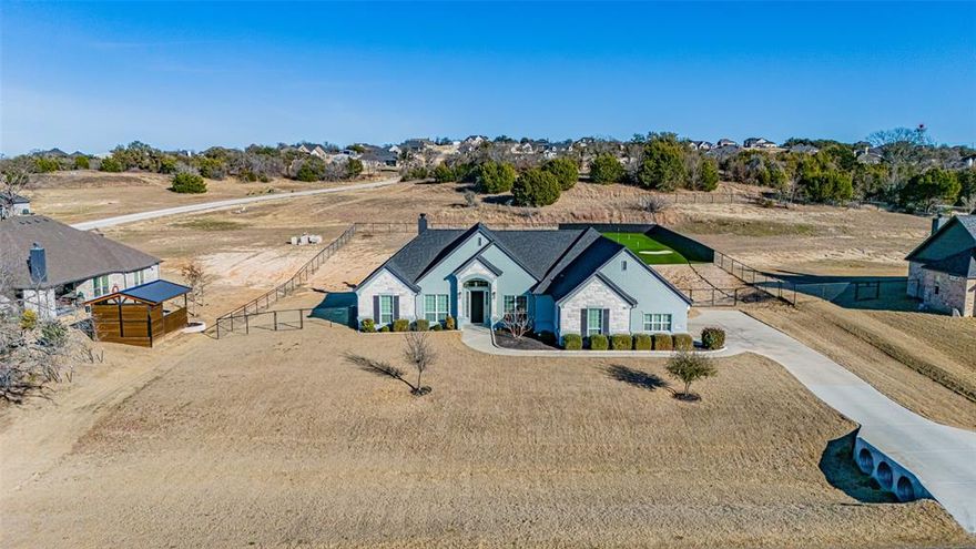 The epitome of luxurious living in this exquisite 4 bedroom, 2.5 bathroom custom home, spanning an impressive layout designed for comfort and entertainment. Nestled in a serene neighborhood of Vintage Oaks, this home boasts a spacious 3-car garage, providing ample storage and convenience for your vehicles and hobbies. Step inside to be greeted by beautiful wood tile flooring that flows seamlessly throughout the entry, main living areas, and kitchen offering both elegance and durability. The heart of the home is the expansive living room, where beamed vaulted ceilings soar overhead, creating an airy and inviting atmosphere. A stunning floor-to-ceiling stone fireplace serves as the focal point, perfect for cozy evenings with family and friends. The gourmet kitchen, adjacent to the living space, features modern amenities and opens to a dining area ideal for hosting gatherings. The Master suite offers a private oasis complete with an en-suite bathroom featuring dual vanities and a luxurious walk-in shower. Efficient tankless hot water heater, ensuring endless hot water. Outside, the fenced backyard provides privacy and security, transforming into your personal retreat. Golf enthusiasts will delight in the custom chipping green, allowing you to practice your short game right at home. As evening falls, the built-in Jellyfish exterior lighting illuminates the property with a mesmerizing glow, highlighting architectural details and creating a magical ambiance. Extend your living space to the covered patio, where another floor-to-ceiling stone fireplace awaits, ideal for al fresco dining or relaxing under the stars. This home isn't just a place to live—it's a lifestyle, blending sophisticated design with practical features for the discerning buyer. Schedule your viewing today and envision your future in this remarkable property!