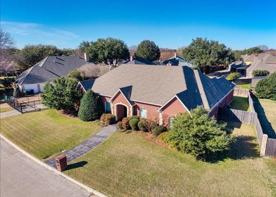 Luxury single-story custom home by Ambassador Homes — first time ever on the market. Impeccably maintained by original owners and never exposed to pets or smoke. This 4-bed (one is used as an office), 2.5-bath residence offers over 3,099 sq ft of refined living with white oak nail-down hardwoods, 10–12 ft ceilings, triple crown molding, plantation shutters, and two fireplaces, including a dramatic floor-to-ceiling Austin-stone centerpiece. The gourmet kitchen features granite countertops, solid ash cabinetry, double ovens, an appliance center, roll-out drawers, a built-in cutting board, and an included GE Profile refrigerator. Audio-wired living areas and primary suite elevate entertainment and everyday comfort.  Primary bath remodeled in 2017 with marble countertops, frameless glass shower, and soaking tub. Energy-efficient upgrades include new windows (2018), new HVAC systems (2019), two new water heaters (2025), and conditioned-space ducting to reduce energy use.  Oversized 3-car garage, extended driveway, iron fencing with gated entry, fully landscaped yard with perennials, and expansive backyard pre-wired for a future pool. Refrigerator, microwave, washer, dryer & safe convey. AT&T fiber installed.  Voluntary HOA.