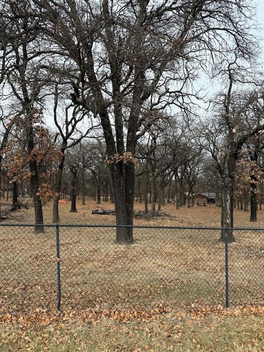 Rare, heavily treed, with a pond, and just over an acre in the heart of Azle.  The space would make a beautiful homesite with room for a shop and pool. Platted, waiting final approval from the City. Septic, water, electric and driveway will need to be installed. Close to the Park, lake, shopping and schools with an easy commute to Fort Worth, Weatherford and Alliance area. Pictures Coming Soon!