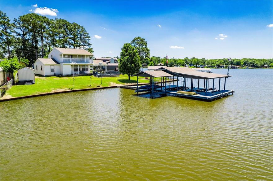 Spacious two-story retreat set on an oversized lot with approximately 114 ft of pristine shoreline.  Enjoy stunning lake views from large picture windows in the generous living area, complete with stylish wood-look flooring.  The light and airy kitchen offers abundant cabinetry and plenty of work space.  With four bedrooms, two full baths and versatile flex room, there's room for family , guests or a home office.  Outdoor living is a dream with a covered porch, upper level balcony and an oversized double boathouse.