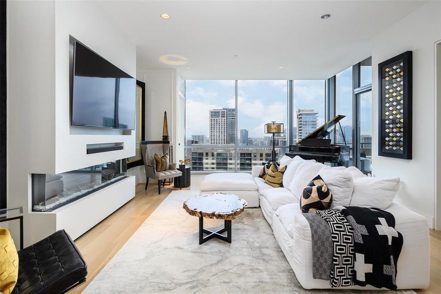 Perched on one of the higher floors of The House, Residence 2401 feels like stepping onto a modern motor yacht gliding above the city with sleek lines, refined finishes, and a sophisticated atmosphere that sets the tone from the moment you arrive. Floor-to-ceiling windows showcase sweeping north and southeast vistas, flooding the home with natural light and highlighting the warmth of the white oak floors. The beautifully appointed kitchen features Crema Marfil marble countertops, Wolf appliances, Sub-Zero refrigeration, and a clean, elegant design that blends seamlessly into the main living space.

The living room centers around a custom fireplace and offers an impressive setting for both everyday living and entertaining, with floor-to-ceiling windows that frame the stunning views beyond. The spacious primary suite includes wide windows overlooking the scenery, along with a spa-inspired ensuite featuring a soaking tub, walk-in shower, dual sinks, and a generous closet. A versatile secondary bedroom functions perfectly as a guest room or stylish home office, supported by a full bath ideal for overnight visitors.

Step onto the private terrace to enjoy evening breezes, a glass of wine, and panoramic Dallas views. All of this sits in the heart of Victory Park, just steps from top restaurants, entertainment, the AAC, and some of the most walkable conveniences in the city.