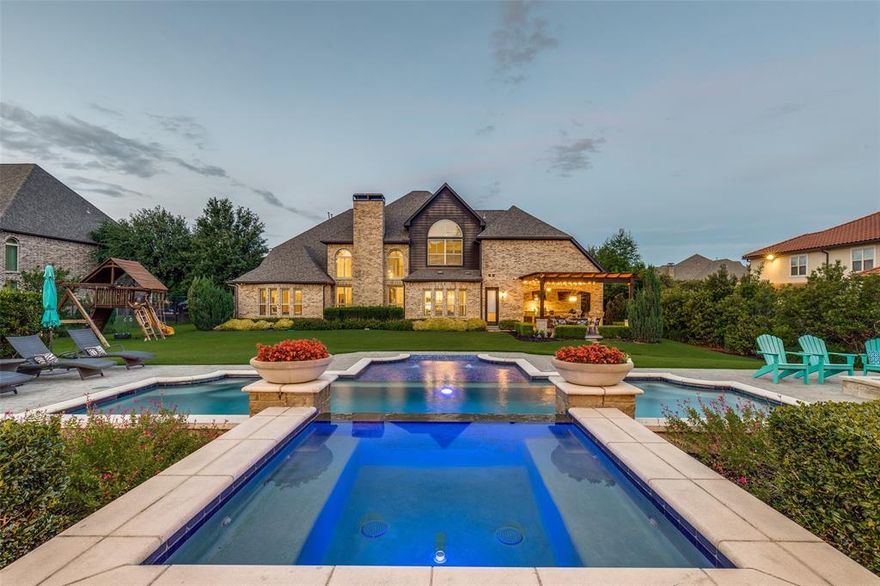 This luxurious estate, set on a 0.69-acre lot in the prestigious Shady Oaks neighborhood, offers an exceptional lifestyle with a million-dollar backyard oasis. Located in award-winning Carroll ISD, this home exudes elegance and sophistication. A grand 32-foot foyer with a curved staircase opens to a bright family room with soaring 20-foot ceilings, a dramatic stone fireplace, and a wall of windows framing the resort-style backyard. The chef's kitchen features a 6-burner cooktop, built-in refrigerator, double ovens, oversized island, and seamless flow into the family and breakfast rooms. The serene primary suite includes coffered ceilings, a garden tub, walk-through shower, dual custom closets, and views of the lush backyard. The main level also offers a formal dining room, wine room, butler’s pantry, private study, guest suite, mudroom, powder room, and pool-access bath, all with hand-scraped hardwood floors. Upstairs, a vaulted game room, oversized home theater (with equipment), wet bar, beverage fridge, and three spacious bedrooms complete the space. The backyard is an entertainer’s dream with multiple lounging areas, an outdoor kitchen, Bocce Ball court, trampoline, fire pit, and a saltwater pool with waterfalls and a hot tub. A stone cabana with vaulted cedar ceilings completes the oasis. Additional features include a Sonos system inside and out, mosquito misting system, custom millwork, second staircase near kitchen, closet systems throughout, and updated roof & gutters (2019) and water heaters (2024). A rare opportunity for the finest in luxury living.