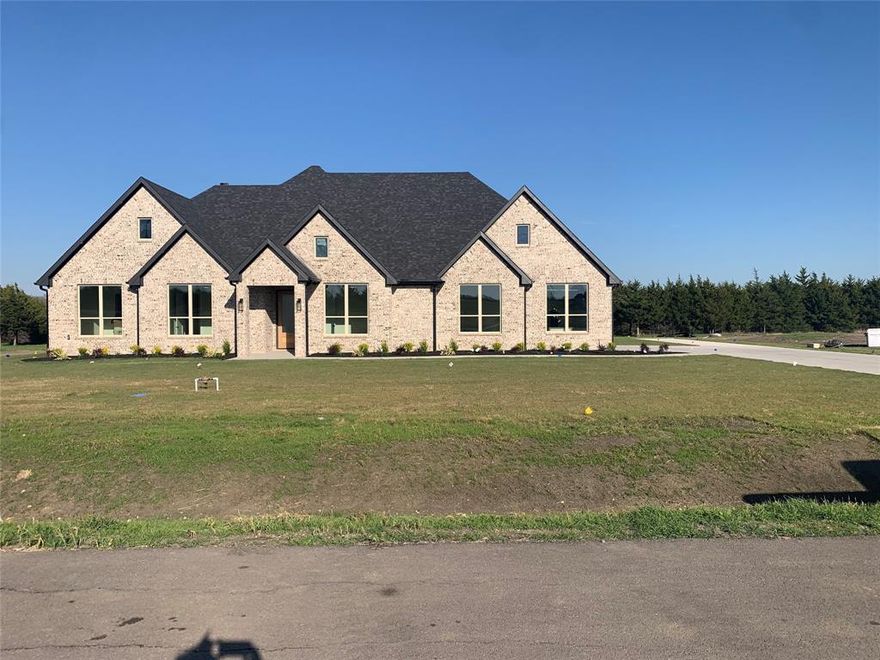 Experience elevated living in this stunning new construction custom-built home offering over 2,800 square feet of beautifully designed space set on more than an acre of land surrounded by mature trees. Designed with both elegance and functionality in mind, this home features four oversized bedrooms and a modern open-concept floor plan that seamlessly blends sophistication with comfort. Dramatic oversized windows flood the home with natural light and showcase peaceful views of the tree-lined property. The expansive living area is anchored by dramatic cathedral ceilings, a sleek modern fireplace, and floating shelves, creating a warm yet contemporary gathering space. Rich wood floors flow throughout the main living areas, perfectly complementing the home’s stylish design. The chef-inspired kitchen is equipped with stainless steel appliances, generous workspace, and modern finishes that make both everyday living and entertaining effortless. Retreat to the show-stopping primary suite, where the spa-inspired bathroom truly steals the spotlight. Indulge in the luxurious freestanding soaking tub, surrounded by the latest in designer tile work, along with dual vanities, a relaxing sitting area, and an oversized walk-in closet that will impress even the most discerning homeowner. Set against a serene backdrop of towering trees on an acre-plus homesite, this property offers the perfect balance of privacy, modern luxury, and space to breathe. With breathtaking design, soaring ceilings, and exceptional craftsmanship throughout, this custom home truly has it all.