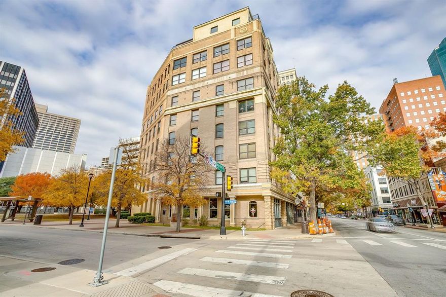 Enjoy downtown living at historic Houston Place Lofts. Open loft with exposed brick and travertine tile. Corner unit with seven windows. Beautiful view of the Flatiron Building. Open kitchen-living, separate bedroom, walk-in closet, updated bathroom, and fresh paint. Same floor parking space. Secured entry to both the building and garage with views of downtown. Next door to entertainment, dining, shopping, and more, including museums and fireworks. Includes refrigerator.  Come and make this one yours!