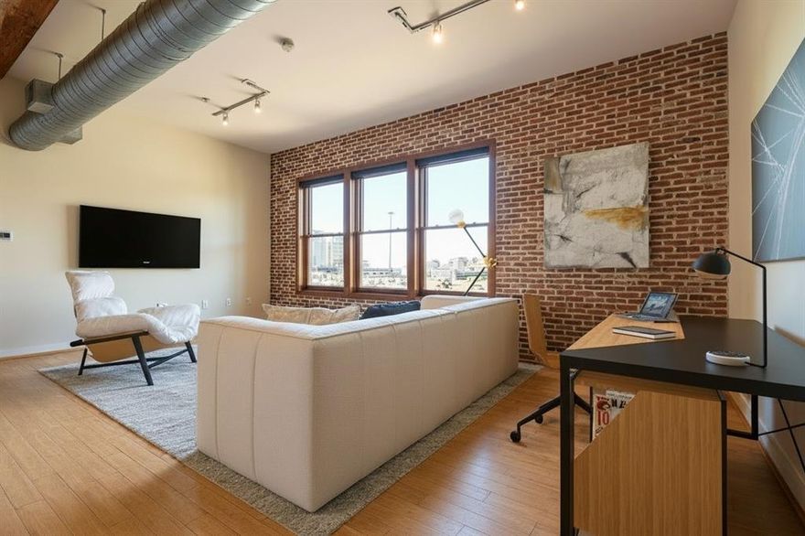 Take advantage of this incredible opportunity to own an updated, oversized 1 Bed, 1 Bath loft condo in the highly sought-after Deep Ellum neighborhood - offering 1,027 sqft of modern urban living with spectacular views of Downtown Dallas. Located on the top floor, this rare loft-style condo blends character, comfort, and convenience in one of the city's most vibrant districts. Step inside to an open floorplan, exposed ductwork & wood beams, and bamboo hardwood flooring that flows seamlessly throughout. The spacious living room showcases a dramatic exposed brick wall, many windows with Signature Series roller shades, and skyline views that define true downtown living. The dining area can also convert to an additional sleeping area, with a cleverly integrated Murphy bed, perfect for guests or flexible living. The beautifully updated kitchen features white cabinetry, granite countertops, stone backsplash, upper and lower cabinet lighting, track and pendant lighting, and a full suite of stainless appliances - including Whirlpool refrigerator, GE cooktop, GE microwave, GE dishwasher, and a double stainless sink with water filtration. Retreat to the private bedroom where you’ll enjoy more stunning city views, designer brushed-gold sconces, a modern ceiling fan, exposed brick, and a stylish barn door leading to the bathroom and closet. The spa-like bathroom offers a marble hexagon tile floor, glass-enclosed marble shower with rain shower head, dual sinks, wall sconce & recessed lighting, and a mirrored medicine cabinet. A custom oversized walk-in closet with dark wood shelving provides exceptional storage. Additional perks include a dedicated laundry room with full-size washer and dryer, updated 5-panel solid doors, upgraded switches & outlets, and much more. The community enhances your lifestyle with a renovated pool and courtyard patio area, grilling pergola, fitness center, and secure parking - all just steps from the restaurants and culture of Deep Ellum.