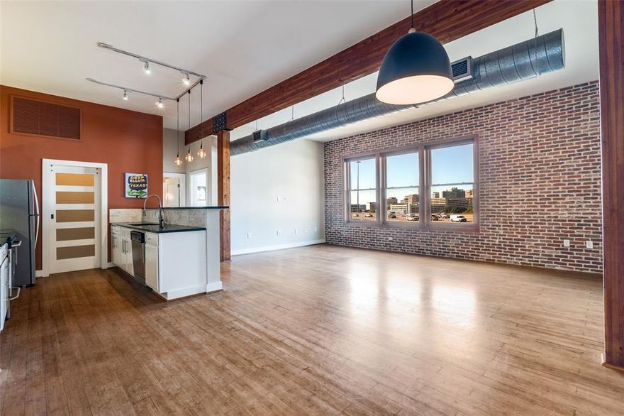 Take advantage of this incredible opportunity to own an updated, oversized 1 Bed, 1 Bath loft condo in the highly sought-after Deep Ellum neighborhood - offering 1,027 sqft of modern urban living with spectacular views of Downtown Dallas. Located on the top floor, this rare loft-style condo blends character, comfort, and convenience in one of the city's most vibrant districts. Step inside to an open floorplan, exposed ductwork & wood beams, and bamboo hardwood flooring that flows seamlessly throughout. The spacious living room showcases a dramatic exposed brick wall, many windows with Signature Series roller shades, and skyline views that define true downtown living. The dining area can also convert to an additional sleeping area, with a cleverly integrated Murphy bed, perfect for guests or flexible living. The beautifully updated kitchen features white cabinetry, granite countertops, stone backsplash, upper and lower cabinet lighting, track and pendant lighting, and a full suite of stainless appliances - including Whirlpool refrigerator, GE cooktop, GE microwave, GE dishwasher, and a double stainless sink with water filtration. Retreat to the private bedroom where you’ll enjoy more stunning city views, designer brushed-gold sconces, a modern ceiling fan, exposed brick, and a stylish barn door leading to the bathroom and closet. The spa-like bathroom offers a marble hexagon tile floor, glass-enclosed marble shower with rain shower head, dual sinks, wall sconce & recessed lighting, and a mirrored medicine cabinet. A custom oversized walk-in closet with dark wood shelving provides exceptional storage. Additional perks include a dedicated laundry room with full-size washer and dryer, updated 5-panel solid doors, upgraded switches & outlets, and much more. The community enhances your lifestyle with a renovated pool and courtyard patio area, grilling pergola, fitness center, and secure parking - all just steps from the restaurants and culture of Deep Ellum.