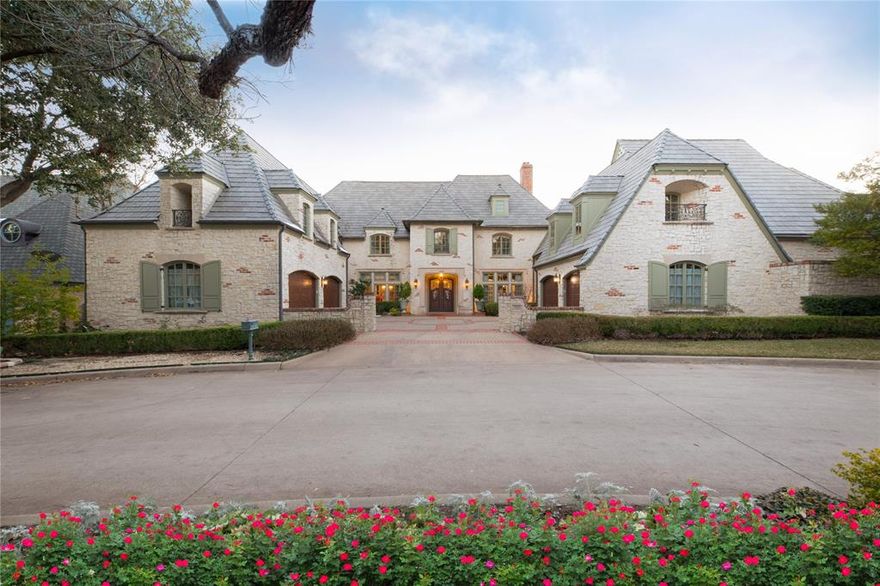 Welcome to this stunning custom home, an exceptional estate in gated Lake Forest, in the heart of Preston Hollow. This luxury community offers an array of amenities, including 24-7 guard-gated security, community pool, walking and running trails, lakes and creeks, pickleball & tennis courts, neighborhood events and clubs, plus dog park & serene natural surroundings, with over 170 acres of lush, tree-filled grounds and four manned gates. Situated on an oversized lot, this home enjoys unmatched privacy with picturesque lake and creek views from most rooms. The grand and elegant interiors include on the first floor a welcoming foyer with a rounded staircase leading to the second floor, spacious formal dining room, paneled library with a fireplace, expansive great room with vaulted, beamed ceilings, seamlessly flowing into the kitchen and breakfast area and bright morning room with walls of windows overlooking the creek. The luxurious first floor primary suite includes sitting area with fireplace, dual walk-in closets & spa-like bath. There is a mirrored exercise room within the primary suite that includes a sauna. Also downstairs is a paneled study with built-in bookcases, wet bar with storage, and two powder baths. The spacious and versatile upstairs includes four en-suite bedrooms, including one that could serve as a secondary primary suite, and one currently used as second office, plus game room with a full bath and media room with projection equipment. This home also has a unique basement with another bedroom suite with private balcony to nature, and an oversized flex space, encased in concrete—perfect for a storm shelter or any number of uses. Additional highlights include elevator to all three floors, a 4 car garage, numerous updates, including to the kitchen and primary bath, and a peaceful, secure and truly one of a kind home. This is a Wow – an elegant retreat offering security, luxury, privacy, and amenities in the center of Dallas!