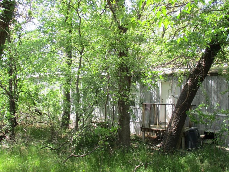 Price update! Motivated seller. Seller financing available, please inquire. Great opportunity for Lake Granbury and the Brazos River living. Interior treed lot located on the Fort Worth side of town with a Windsor three bedroom, two bath split bedroom floor plan manufactured home on it that could be restored by the right person but is not currently habitable. Kitchen features include plentiful cabinetry including glass front dinnerware display cabinetry, island and a dining nook open to living area. Owners suite features a walk in closet and large bathroom with storage shelving and garden tub with shower combo. Lake Granbury is visible from the tree lined street view and boat dock with launch is within walking distance.  Great location to enjoy fishing, boating, water sports or simply relax.