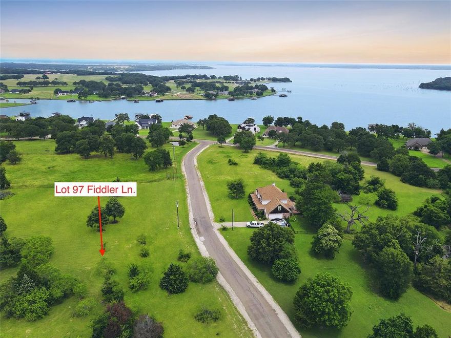 Discover the perfect place to bring your lake-life vision to life on Lot 97 in the Vista Ridge subdivision on Richland Chambers Lake. This 1.28-acre unimproved lot offers a level, build-ready homesite positioned atop the ridge, providing a peaceful setting surrounded by rolling terrain and scattered mature trees. With approximately 236 feet of road frontage along Fiddler Lane, there’s plenty of flexibility for home placement, driveway options, and outdoor living design. As an off-water lot, you’ll enjoy generous space to build a custom home with features like a wrap-around porch, pool, garden, or outdoor kitchen—without the congestion often found on waterfront parcels. Residents of Vista Ridge have access to a community boat ramp and common lake amenities, making it easy to enjoy days on the water while returning home to quiet, open surroundings. Vista Ridge is known for its wide-open spaces, gently rolling hills, and scenic countryside feel. The subdivision features site-built home restrictions, a minimum 2,000 square feet, and no required timeframe to build, allowing you to plan at your own pace. Utilities are installed, streets are in place, and the property is located outside city limits in Mildred ISD. Ideally located roughly midway between Dallas and Houston, Richland Chambers Lake is one of Texas’ largest reservoirs and is prized for its calm waters, excellent fishing, and relaxed lake lifestyle. Whether you’re building a weekend retreat or a full-time residence, Lot 97 offers space, flexibility, and easy access to everything lake living has to offer.