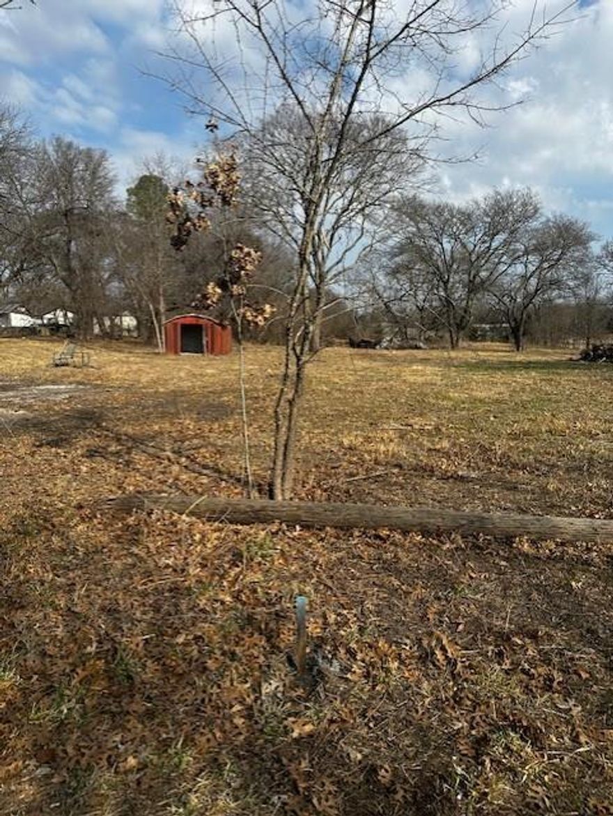 Located in the city limits of Bells, this lot joins two other lots the same owner has for sale as are listed on MLS numbers 21177971 and 21177957.  This small lot would be an asset to either or both of the adjoining lots to allow more space to build a house with plenty of room for your outdoor activities. This property at one time, had a house on it with city water and a septic tank. The house was bulldozed down several years ago and it and the lot were cleaned up. The water meter box was located and is marked with orange paint. Contact City of Bells for availability of a water meter purchase. The lot alone is too small to install a septic system in compliance with City of Bells and Grayson County regulations. At this time the City of Bells, does not have sewer taps available for sale. The boundary of this lot has been approximately staked off for an idea of where the lot lines are.  A survey will need to be done to verify actual lot lines. All information is deemed to be accurate and correct by owner and listing agent but is the responsibility of the buyer and or buyer's agent to verify all information with the City of Bells.