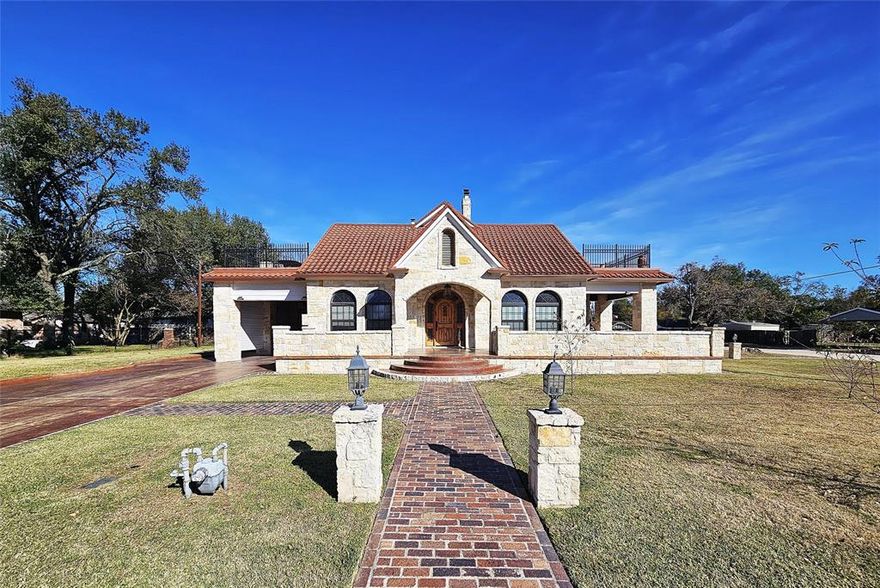 Spacious Texas country home meets Spanish style villa!  Located in the heart of one of Groesbeck's most desirable, established neighborhoods on almost a half an acre.  The home's original 1924 exterior brick has been utilized to form beautiful sidewalks that wind around the property.  The Austin stone exterior features an extensive wrap-around porch, terra cotta style tiled metal roof, attached carport, spacious driveway that leads to a back patio perfect for entertaining.  The home's charming interior features over 4,000 square feet with 4 bedrooms and 4 bathrooms in the main home, 2 living rooms, formal dining space and two additional rooms that could be utilized for home offices, or additional bedrooms if needed.  Primary bedroom with attached bathroom is located on the main floor and features a walk-in closet, bathroom with sunken jetted bathtub, separate river rock floored shower, and more!  Two of the upstairs bedrooms feature private access to nice sized terraces overlooking the neighborhood.  So much of the original character throughout including a gorgeous original staircase, built-ins throughout, 3 fireplaces, 11' ceilings, pocket doors, French doors and more. The spacious kitchen features an abundance of cabinets, top-of-the-line appliances (Viking gas range), separate breakfast nook, dishwasher and double ovens.  Additional upgrades include a geo-thermal HVAC system, black fiberglass windows, tankless instant hot water heater, and more.  Property also features a unique 2 story carriage house with storage on the first floor and an additional bedroom with its own private half bathroom upstairs.  This home is a showstopper!