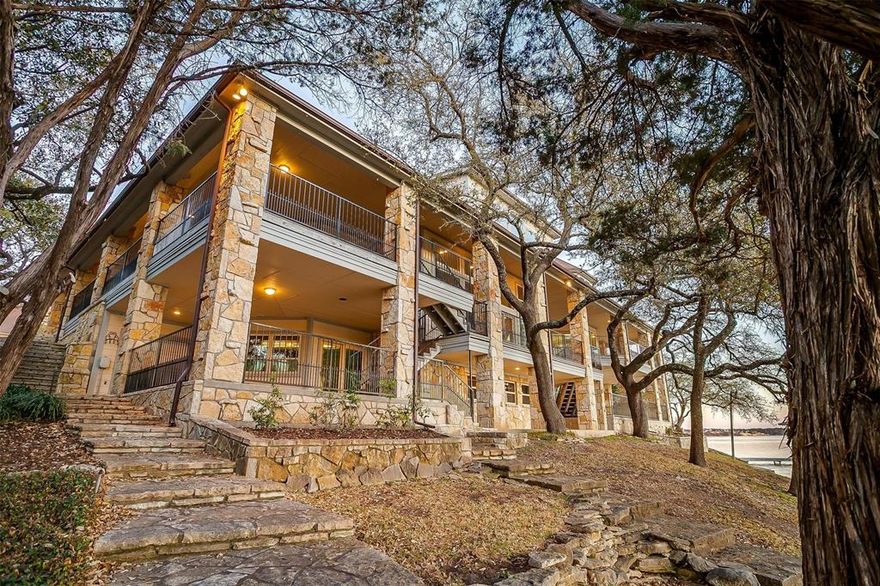 GORGEOUS WATERFRONT PROPERTY in coveted DeCordova gated community! This luxurious estate is located on both the main body of the lake & a peaceful canal. The main living boasts of soaring vaulted ceilings, stunning floor to ceiling stone fireplace, game room with expansive plate glass windows & stunning lake views, plus custom wet bar. Primary bedroom has gorgeous custom dual sliding glass doors, impressive lake views from private covered balcony, two large walk-in closets and recently remodeled primary ensuite bath. Ensuite bath has dual sinks with separate vanities, dual toilet rooms, large walk-in shower and soaking tub with stunning chandelier. 8 charmingly unique bedrooms, 9 baths, crow's nest study, large media room & lower level art studio. 2 bedroom apartment located over garage, includes kitchenette, Boys & Girls bathrooms & adorable built-in playhouse. Covered boat dock is nestled mid-center of just under 300 feet of waterfront, includes boat & jet-ski lifts. This property is perfect for entertaining & sure to impress!!