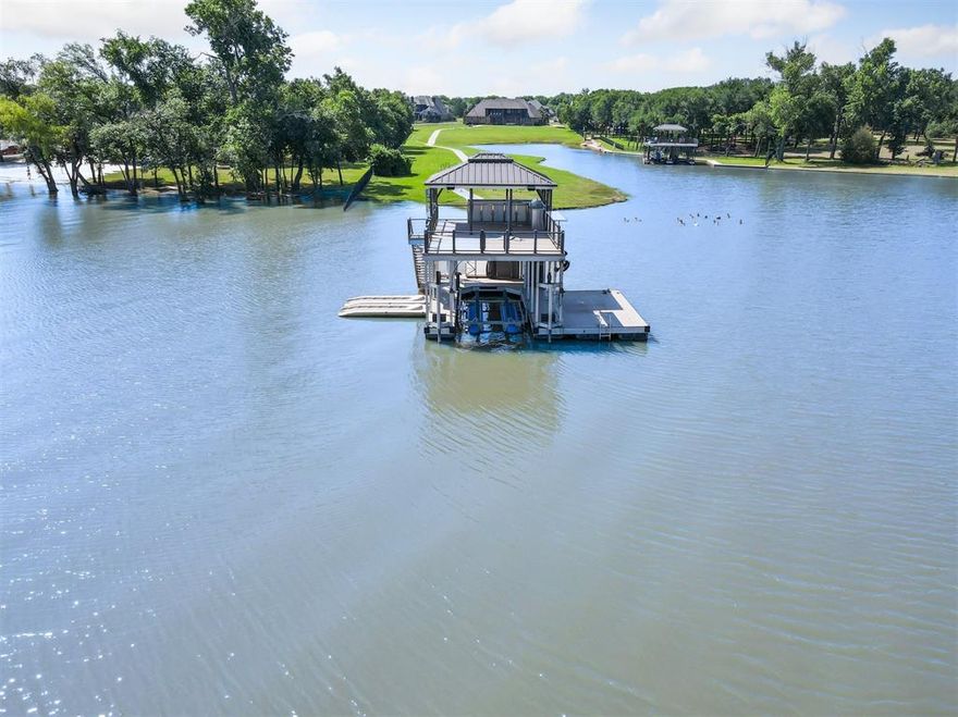 Lakefront Luxury Retreat on Eagle Mountain Lake. Experience the ultimate in lakeside living on this stunning 3.74 acre estate, located in an exclusive gated community just minutes from downtown Fort Worth. Boasting 650 feet of pristine water frontage on Eagle Mountain Lake, this exceptional property combines elegance, comfort, and resort-style amenities.
This custom crafted residence features 6 spacious bedrooms, 4 luxurious bathrooms, a dedicated office, and a flowing open concept living and kitchen area designed for entertaining. The gourmet kitchen is a chef’s dream, complete with granite countertops, a built in commercial refrigerator, double ovens, gas cooktop, oversized island, breakfast bar, expansive walk-in pantry, and a convenient butler’s pantry.
Thoughtfully appointed throughout, the home showcases hand-scraped wood floors, plantation shutters, custom chandeliers, and remote-controlled window shades. A mud bench area, large laundry room with built-in cabinetry, sink, and space for a second refrigerator provide everyday practicality. Upstairs, guest quarters with kitchenette and private balcony access offer the perfect retreat.
Step outside to your personal paradise: a covered patio with outdoor fireplace and misting system, built-in grill, fire pit, putting green, and a concrete walking, golf cart path from house leading to the water. The two-level dock features two jet ski ramps, tanning deck, and a boathouse equipped with a grill, sink, full-size refrigerator, water heater, and misters ideal for lakeside entertaining.
Additional features include a three-car garage, and is fully irrigated using lake water via a pump fed sprinkler system.
This is more than a home, it’s a lifestyle. Luxury, privacy, and recreation await at this one-of-a-kind Eagle Mountain Lake estate.