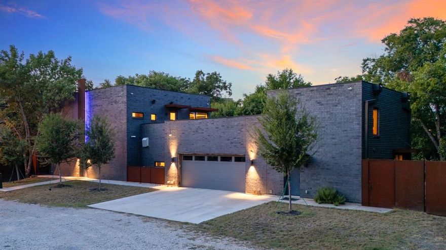 This modern take on a European walled compound knocks it out of the ballpark. Completed in 2021, the home was inspired by vacations in Spain but realized as a modern design featuring commercial quality materials, including an oversized Acme Iron-spot brick and artisan steelwork. Located on .445 acres, the “compound” features 3 separate living spaces, the 3 bedroom, 3.5 bath main house + the attached 2 story apartment + the 1260 sq ft detached 2 bedroom, 2 bath guest house. County measurements total everything, including the attached garage, as 5486 sq ft. Each structure is foam insulated. Situated on a cul-de-sac, beyond its gated driveway and fortress-like facade, one is connected immediately to nature. The NE boundary is the wooded Old Trinity River Channel. Designed for multigenerational living, the property is very well suited for creatives who want a live work homebase in separate but connected facilities. There are open living areas with polished concrete floors and tall ceiling rooms flooded with natural light.  A covered porch is the perfect place to take in the home’s central “green” and there is a roof top terrace. Appliances include a Dacor 36” stainless-steel refrigerator, freezer, and 24” wine fridge. There are Blue Star double ovens with and a Blue Star 8-burner gas range. Stainless-steel countertops with integrated sinks will please the most discerning chefs! On the 2nd floor of the main home are 3 bedrooms & 3 baths, each with decorator tile. The primary suite has a walk-in double shower with a view of the skyline. The 2-story loft apartment has its own entrance. Detached is a luxurious 2 bedroom guest house with an open living area, full kitchen, 2 custom baths, and a covered porch. MU-1 Zoning allows for multiple uses. Surrounded by live-work residences, galleries and showrooms, the lot size and nature preserve setting make this home a one-of-a-kind.