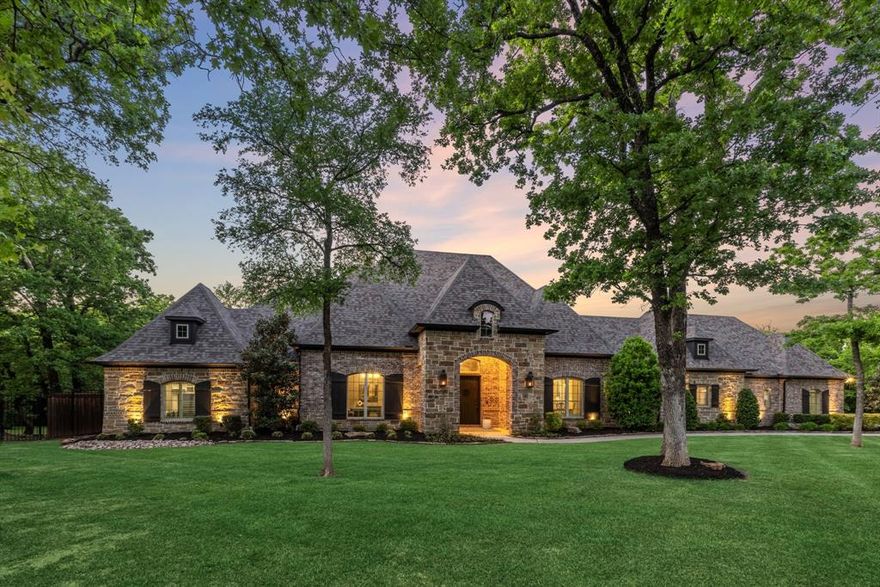 Set behind the private gates of Waters Edge, this estate exists in a category rarely found where land, privacy, and construction integrity converge into something truly exceptional. Spanning nearly two acres across a rare double lot and backing to protected Corps of Engineers land, the setting offers a level of seclusion that cannot be replicated with no rear neighbors, no future development, just uninterrupted natural surroundings moments from Lake Lewisville. Crafted with an uncompromising approach to quality, the residence is engineered as much as it is designed, with extensive piers beneath both the home and pool, spray foam insulation, and materials selected for longevity as much as beauty. Every space reflects intentional design, from the architectural beam work and vaulted ceilings to the custom millwork carried throughout. The main living areas unfold with quiet sophistication and anchored by a statement great room and a kitchen appointed with custom cabinetry, an oversized island, and a full suite of professional-grade appliances. Entertaining transitions effortlessly to a lower-level game room with wet bar and serving windows, and a dedicated media retreat designed for immersive experiences. The primary suite is privately positioned with a bath that rivals a spa including a steam shower, freestanding tub, fitness room, and a boutique-style closet with integrated vanity space. Thoughtful additions including secondary living spaces, and ensuite accommodations throughout create flexibility without compromise. Outdoors, the estate transforms into a resort environment with multiple covered living areas, a fireplace lounge, built-in grilling station, and a pool with spa and waterfall, all oriented toward the uninterrupted backdrop of protected land. With capacity for five vehicles, generator readiness, and future guest house potential, this is more than a home, it is a long-term legacy property defined by privacy, scale, and enduring quality.