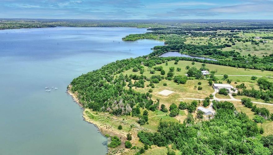 Nestled along the shores of Lake Ray Roberts, this 35-acre lakeside property offers an unmatched blend of natural beauty, privacy, & recreational opportunities. With expansive lake views, about 700ft of shoreline, and vibrant Texas sunsets as your backdrop, the land is rich in character, featuring a mix of trees, pasture, and a pond, creating the best of country living. The property offers a premium build site with panoramic lake views setting the stage for a future custom home.  Presently, there is a newer modular home with lake views that offers a comfortable space as a temporary residence while you build, a weekend or full-time residence, or a guest home. The 50x60 shop offers a range of possibilities with its spacious layout & partially finished enclosed flex space. The shop includes 3 overhead doors, 1 with extra height for RV storage. Inside, the foam-insulated, climate-controlled flex space spans approx 1,800sf. The space is partially finished, giving you the opportunity to complete it to your liking. The main level is laid out for a lounge or game room with a pre-wired & pre-plumbed kitchen area, a bonus room with closet, & a full bath with washer & dryer hookups. Upstairs, enjoy lake views from a planned office space, 2 storage closets, a 2nd full bath, and a large storage room. HVAC, water, & plumbing are in place, and materials for finishing, including flooring, stainless induction cooktop, wall oven, and an electric fireplace are included & ready for installation. The property has a current wildlife exemption, helping keep property taxes low. It’s also equipped with high-speed fiber internet, a high-capacity aerobic septic system designed to support an additional home, & a 350-amp underground electric service, providing plenty of power for future expansion. With convenient access to major amenities and recreational attractions, 1529 Hemming Road is about 6 miles east of I-35, providing a sensible commute to the Metroplex & the DFW Intl Airport.
