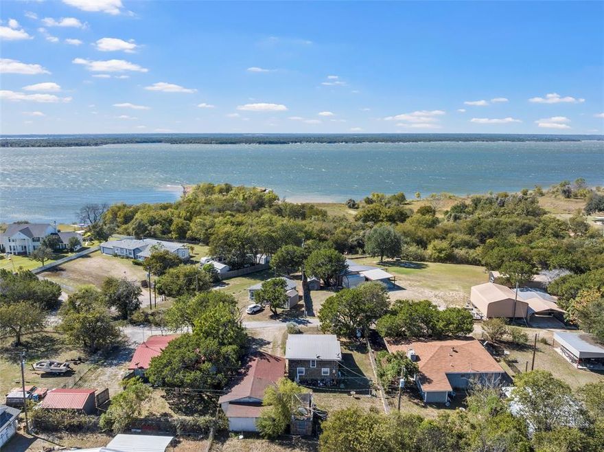 This charming property near Lake Whitney features two separate living spaces, making it a great opportunity for a first home, weekend retreat, or income-producing short-term rental. The main home offers a cozy 1-bedroom, 1-bath layout with a loft-style bedroom overlooking the open living and dining area. Large windows fill the space with natural light and highlight the warm wood accents and flooring. The  Garage Apartment, also a 1-bedroom, 1-bath, is located just behind the carport and is perfect for guests, extended family, or use as an Airbnb to help offset your mortgage. With a fenced yard, durable metal roof, and walking distance to both the lake and The Place at Lake Whitney wedding and event venue, this property combines comfort, flexibility, and location—an ideal setup for enjoying the best of Lake Whitney living.