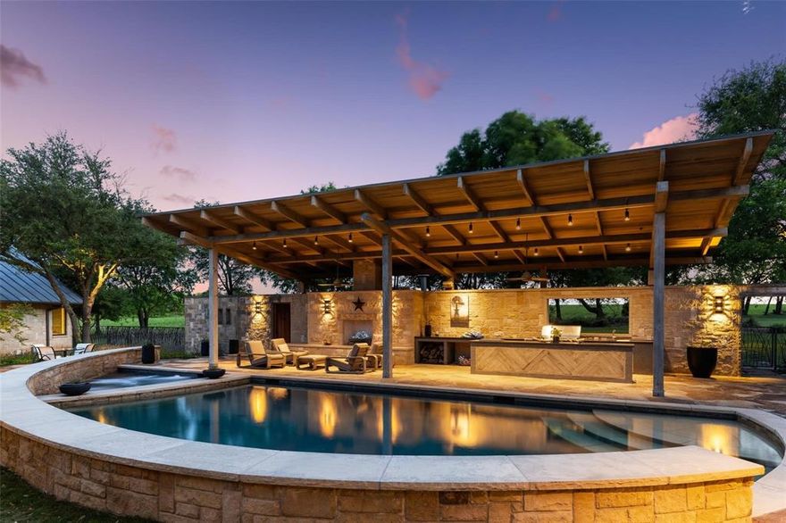 This Texas Hill Country inspired home brings modern country living to the City of Frisco. Situated on a very rare 2.5 acres, the Custer Creek Farms home has the perfect layout for long term guests, multigenerational needs, or working from home. This high-end custom masterpiece exudes quality in every detail from the vaulted ceilings, quarry stone & museum finish walls to the perfection of the landscape lighting. Level one you'll find the primary suite, a study, & theater room in addition to the living and dining areas. The primary bedroom is a peaceful retreat with gas fireplace and overlooking the pool while the luxurious bathroom provides heated floors, a handcarved Texas limestone tub, and generous walk in shower.  Open the bathroom double doors to experience the water feature, while still having privacy. The walk in closet includes the convenience of a stackable washer and dryer. Function and beauty describe the kitchen equipped with Viking appliances, soapstone countertops, double sinks, and walk in pantry. It overlooks the front drive and the patio for dining al fresco. Head up the oak & limestone staircase to find 3 bedrooms, all en-suite. The private backyard oasis includes a solar heated pool & hot tub, built-in bar & kitchen, 2 fireplaces, 2 water features, an outdoor bathroom and a safe room which is F4 tornado rated. The luxury barn consists of an additional 2 bedrooms, 2 baths, a laundry room, kitchen, living room and bonus rooms. Oversized 5 car garage plus covered space for an RV or tour bus with sewer and electric hookups in the barn. The carriage house has endless possibilities & could be a 10 car showroom for car enthusiasts, a large gym, a space to run a business, or it could be torn down to add another residence. The grounds are all watered by rainwater capture with water bills almost non-existent. NO mandatory HOA. 1 Horse allowed per acre. Barn included in MLS SF. Carriage house not included in MLS SF.