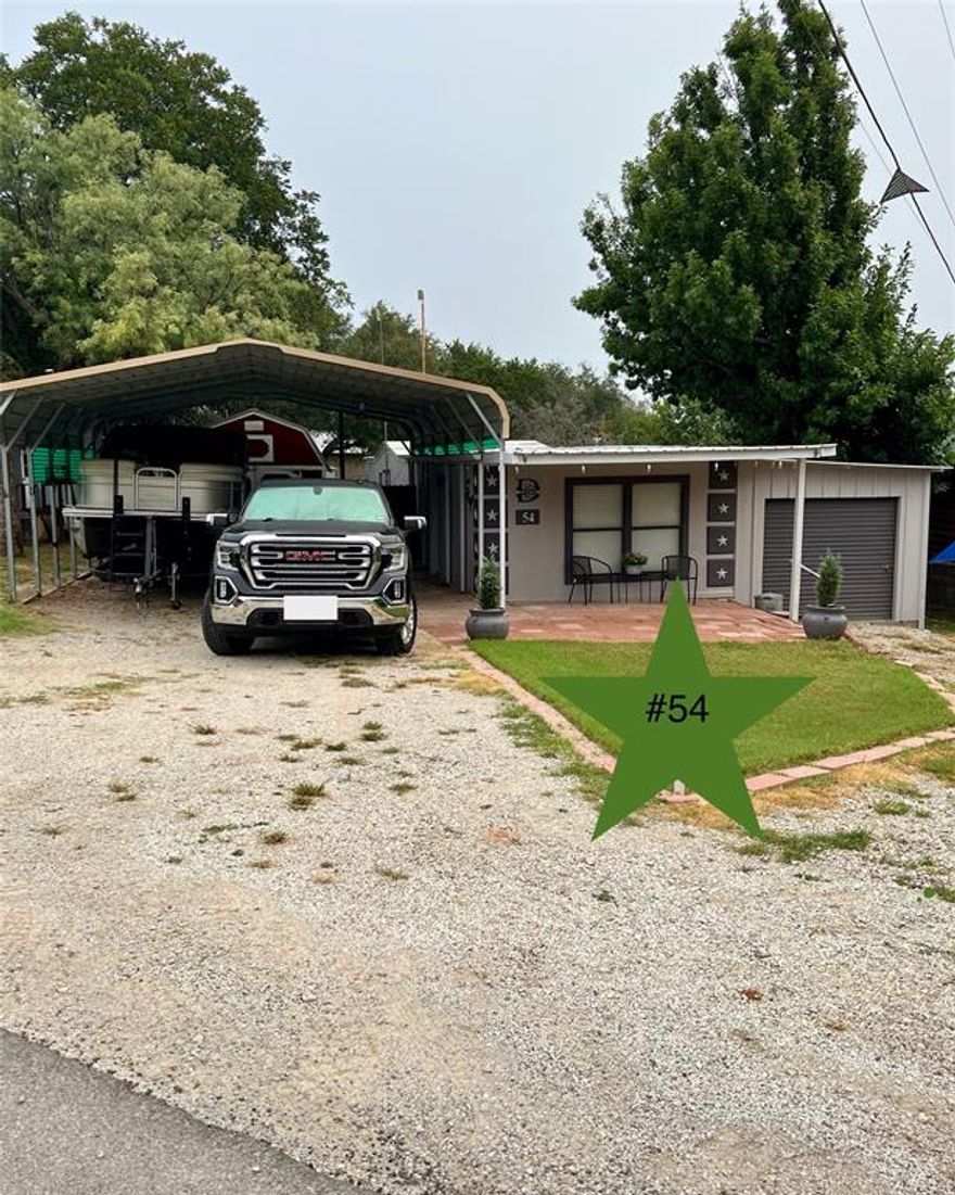 Looking for a lake place that provides serene surroundings, a friendly community, and low maintenance?  Here it is, just waiting for you in Golden Cove on Possum Kingdom Lake! Several years of continuous upgrades and improvements make this awesome lake place a hidden jewel! This stucco finished home has been fully redone from the floors up. Features include a metal roof, covered patio, detached carport with enough room for watercraft or RV, attached garage with roll up door with room for atv or golf cart, separate storage shed, and a spacious covered deck with a bar, outdoor cooking area, and LAKE VIEW overlooking the swim cove. Inside you'll enjoy an open living-dining concept, new sub-floors and vinyl plank flooring throughout, a new stainless steel appliance package, living room fireplace, stacked washer & dryer, two bedrooms - one with en-suite bath, plus a  bonus room with a wood-burning stove that opens to the back deck. Nicely furnished and ready for new owners!  Must see to appreciate! Monthly lot lease $865