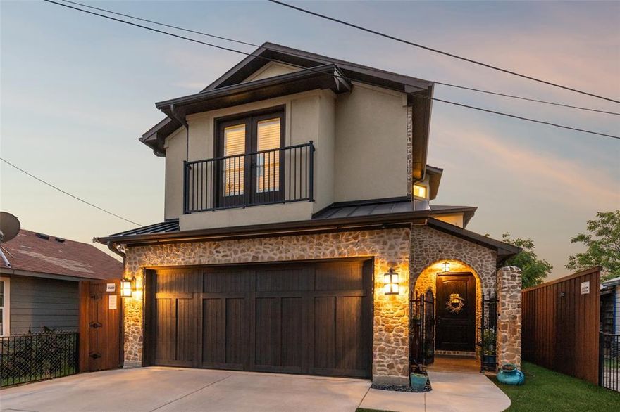 Sellers are offering a 1% Rate Buydown! Experience the perfect blend of luxury, design & location in this stunning stucco & stone residence in the heart of Trinity Groves, just steps from some of Dallas’ most exciting restaurants, retail & entertainment & minutes from Downtown, Uptown, Klyde Warren Park, the Design District + more. Crafted w-enduring quality & style, the home boasts an impressive 8ft cedar fence set on a 2ft cement footer, lush artificial turf w-sprinkler system, black iron sconces & a stone patio with a built-in outdoor kitchen & griddle, ideal for entertaining. Inside, soaring ceilings with rustic wood beams, custom iron stair railings + solid wood interior doors pair beautifully with luxury vinyl flooring throughout & porcelain tile in wet areas. Chef’s kitchen showcases a dramatic oversized island with leathered granite, GE Monogram appliances, pot filler, built-in refrigerator + custom cabinetry, while the dry bar offers an icemaker, dual beverage drawers + a wine fridge. The spacious primary suite is a true retreat w-vaulted ceilings, a Juliet balcony overlooking the Margaret Hunt Hill Bridge, dual WIC & a spa-inspired bath featuring a soaking tub + an expansive WI stone shower. Additional highlights include remote-controlled shades, a custom stone FP w-rustic mantel, extensive garage cabinetry, tankless water heater & wired security cameras. Energy encapsulation ensures efficiency & soundproofing, while decorative awnings & premium finishes add timeless character. With direct access to the upcoming Harold Simmons Park—a 250-acre riverfront destination offering trails, gardens, kayaking, pickleball courts, and an amphitheater—this home is perfectly positioned in one of Dallas’ fastest-growing & most desirable neighborhoods. Whether enjoying quiet evenings at home, hosting unforgettable gatherings, or embracing the vibrant culture of Trinity Groves and the Tin District, this one-of-a-kind property delivers the very best of luxury urban living.