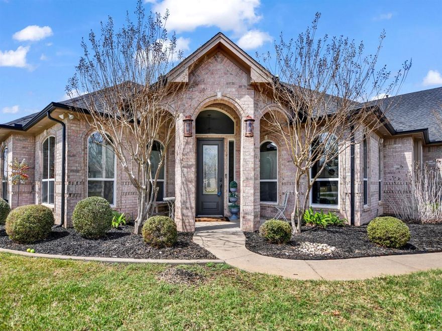 Impressive curb appeal welcomes you from the moment you arrive at this corner-lot home, nestled in the heart of the gated & guarded sought after neighborhood, Pecan Plantation. This spacious home blends modern upgrades with timeless charm, offering both style and long-term functionality. 
Inside, the open-concept layout is filled with natural light and features a front office with ample windows. The main living area is anchored by a massive brick fireplace with hearth and built-ins, creating a warm and inviting focal point. Tile installed in 2021 adds both beauty and durability.
The chef-inspired kitchen is designed for everyday living and entertaining, offering abundant cabinetry, generous counter space, and a convenient breakfast bar. The oversized laundry room includes a sink and extensive cabinet storage for added functionality.
The first-floor primary suite features an oversized en-suite bath with dual vanities, walk-in shower, freestanding tub, and a large walk-in closet. This home features spacious bonus rooms, one with built-in bar space, ideal for entertaining, media, or flexible living.
Step outside to an impressive oversized outdoor living space, built-in rock fireplace, built-in grill, and ample exterior countertop space, perfect for hosting or relaxing year-round with golf course views!

The 3-car garage plus additional golf cart garage provides exceptional storage and convenience, ideal for easily pulling out your golf cart to cruise the neighborhood or storing lawn equipment.

Major improvements include AC units (2023) and attic roofline spray-foam (2023) delivering enhanced energy efficiency and year-round comfort.

Residents of Pecan Plantation enjoy unmatched amenities including golf courses, airstrips, equine facilities, parks, pools, pickleball and tennis courts, on-site grocery, dining, and more.

A rare opportunity to own a beautifully upgraded home with space, comfort, and lifestyle at the forefront.