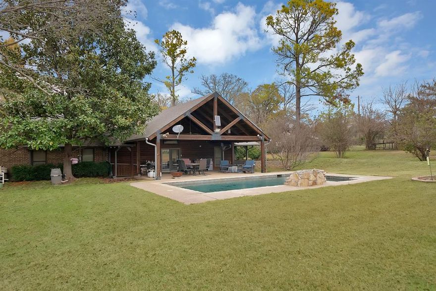 Welcome to this multigenerational property that is perfectly designed for comfort, function, and opportunity. Nestled behind a beautifully tree-lined driveway sitting back off a country road, this spacious home features expansive front and back porches that are ideal for relaxing or entertaining alongside the stunning pool. It also offers nature lovers many opportunities with all the wildlife, wild fruit bushes and trees, a tank and tons of land for livestock or gardening. There is plenty of room for an arena to be built. The main house offers 4 bedrooms with 3.5 bathrooms, 2 living and 2 dining areas. The custom barndominium ,being the second home on the property, offers an open concept living and kitchen with 3 bedrooms and a large bathroom with a utility room.   There is a large barn, 5 stalls, corral, and a vast pasture with a tank and well out in the pasture. With three water wells, agricultural tax exemption, and no known restrictions, this property offers true flexibility for a variety of uses. Bring all the animals and enjoy your own ranchette or make it into an income producing investment property. Additional features include a chicken coop, an indoor and outdoor dog kennel, a dedicated dog grooming space, and a large workshop. Whether you’re seeking a peaceful country lifestyle, a multigenerational retreat, a place to call home with multiple shops and plenty of room to add on or an investment property, the possibilities here are truly endless. So many possibilities with all the land and terrain. Game feeders, hunting blind, chutes gates, 3 safes, all tv's, washer and dryer, refrigerator, and front porch swing all convey. With all this and more to offer come and make this your dream home! Come out to see what all this property has to offer.