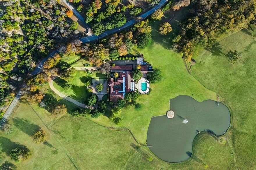 Discover an extraordinary jewel just minutes from Fort Worth along the prestigious Jenkins Road, a 32-acre estate that defines refined country luxury. Blending architectural artistry with serene natural beauty, this one-of-a-kind property is masterfully designed by the renowned Weldon Turner and constructed by the esteemed Rick Yuill, showcasing unparalleled craftsmanship from hand-cut stone to custom brickwork. Upon entering, you’re welcomed by the grandeur of reclaimed wood floors, soaring beamed ceilings, and expansive floor-to-ceiling windows that frame breathtaking views of the surrounding landscape. The show stopping great room exudes sophistication with its dramatic stone walls, grand fireplace, and bespoke built-ins, creating an atmosphere that is both warm and elegant. The primary suite is a sanctuary of comfort and indulgence, featuring oversized his and her closets, dual en-suite baths with heated floors, a private sitting area, a nap room, gift wrapping rooms, and gym with a separate entrance. The gourmet kitchen is complete with its own fireplace and sunlit breakfast nook, providing an inviting setting for intimate gatherings and luxurious daily living. With four spacious bedrooms, each offering its own ensuite bath, along with a generous study or secondary living space, the home is designed for both privacy and effortless entertaining. Outdoors, the estate unfolds into a picturesque haven with a sparkling pool, a 2,500 sq. ft. barn, and a serene private lake that connects to a tributary of the Trinity River. The expansive acreage, thoughtful layout, and prime location also make this an exceptional opportunity for a high end equestrian property or multi-generational estate. This property is more than a residence, this is a legacy, an invitation to experience elevated living with the rare convenience of proximity to Fort Worth.