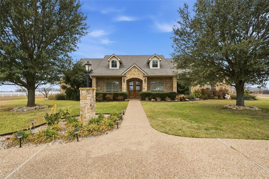 Peaceful country living with room to breathe in Lorena ISD, just minutes from town. This beautifully designed 4 or 5 bedroom, 3.5 bath home sits on 2.663 acres & offers the perfect blend of space, comfort, & functionality. Whether you envision adding a pool, playing ball, or simply enjoying the outdoors, this property delivers wide open possibilities. Inside, the home features both a formal dining room & a breakfast area, giving you room for gatherings big & small. A wall of windows stretches across the back of the home, flooding the living spaces with natural light & offering serene views of the expansive backyard. The kitchen is equipped with granite countertops, custom cabinetry, a large island, gas stove, & refrigerator that conveys, perfect for everyday living & entertaining. A functional built in desk area with shelving provides an ideal space for homework, homeschooling, or a home office, while the mudroom with backpack hooks & storage keeps life organized. The laundry room is close by with a washer & dryer that conveys, room for an extra fridge, & plenty of cabinet and folding space. The isolated primary suite is a true retreat, featuring dual granite vanities, two walk in closets (one built as a storm shelter or panic room), a jacuzzi tub, tile shower with bench, & abundant cabinet space. Plantation shutters add timeless style throughout. Upstairs, a generous bonus room offers flexibility as a fifth bedroom, playroom, or media room. Additional highlights include spray foam insulation, walk in climate controlled attic storage, two tankless gas water heaters, a roof that was replaced in 2023, fresh paint, & a 14 SEER zoned HVAC system. Outdoors, enjoy mature oak trees & a variety of fruit trees: plum, peach, apple, fig, pear, & pecan. A 24’ x 16’ barn or workshop, three car garage with storage & dual workbenches, circular drive, & spacious covered patio make this property as practical as it is peaceful, perfect for sunset views or morning coffee.