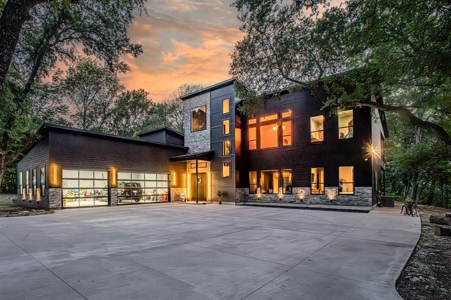 Welcome to an unparalleled masterpiece where modern luxury meets serene sophistication on 2.47 acres backing a private creek. This custom-designed smart home redefines elegance with soaring ceilings, Woodland Reserve Creekside Sawn White Oak wire-brushed hardwood floors, and quartz countertops throughout. The chef’s kitchen boasts Zline appliances, including a 48” propane stovetop with double oven, 30” wall oven and microwave, double dishwasher, and under-cabinet beverage fridge, complemented by waterfall quartz countertops and matching backsplash. Two 32” KRAUS Bellucci granite composite sinks enhance functionality, while a walk-in pantry with a sink adds convenience. The main living area features a gas fireplace with built-in storage, a floor plug for flexible layouts, and a glass-enclosed wine cellar. Retreat to the master suite with a light-up ceiling, electric fireplace, and spa-like bathroom offering an Alpha bidet, dual shower with rain head, skylight, and stand-alone garden tub. Smart home technology, including Z-Wave switches, 5 alarm cameras, and 3 touchscreen control centers, allows seamless control of lights and thermostat. The media room, hidden behind a bookshelf door, boasts a 132” projector screen, 8K Ultra-HD receiver, and MartinLogan speakers, plus a beverage fridge and private balcony. Outside, a wood-burning fireplace warms the back patio, joined by an outdoor kitchen with a Traeger Timberland XL and kegerator. Titanium black quartzite stone, cedar siding, and black modern pebble landscaping frame the shingle-roofed estate, with a 3-car extended garage and custom black-trim windows. A 1,260 sq ft metal building with an 840 sq ft porch, pre-plumbed for a bathroom, offers endless possibilities. Experience luxury living with unmatched privacy and creek views. Schedule your private tour today!