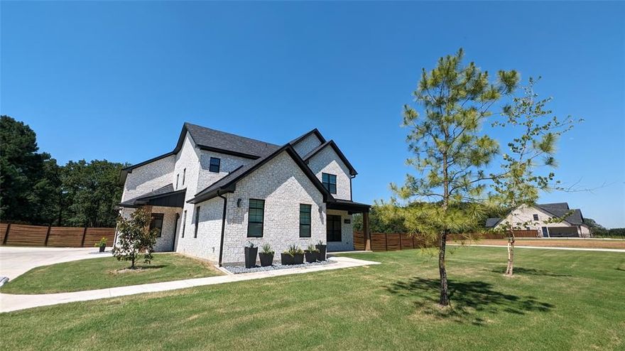 Come explore our EarnhartBuilt personal home and see the extra details we poured into every part of the build. Tucked just beyond the city’s edge, you can avoid their taxes while enjoying a quiet 7-lot community where kids find friends and deer wander into your backyard from our 200 acres of surrounding wildlife land. Formed from hand-chopped brick and layered with character, it’s a home built with care, intention, and a few quiet surprises along the way.

Step inside to 10-foot ceilings, natural light pouring through oversized windows, and hand-woven blinds that soften each ray. Upstairs ceilings are 9-ft tall. Every inch has been thoughtfully designed. From the hidden AV rack under the stairs to Cat6 wiring in every room, abundant outlets throughout, and a convenient laundry chute, functionality is everywhere. Behind one of several accent walls, a secret room waits to be discovered.

The kitchen features white oak cabinetry topped with striking Calacatta Laza quartz, while the bathrooms are finished in high-end tile and frameless shower glass that evoke the feel of a boutique spa rather than a standard new build. Smart locks and timed exterior lights add security and convenience. Solid-core 8-foot doors, a fire-glow electric fireplace, and three-zone audio throughout elevate the everyday experience.

Comfort meets efficiency with dual HVAC systems, spray-foamed 2x6 walls, insulated porches and garage prepped with an EV plug. The closet is its own kind of luxury, complete with a vanity, lighted mirror, hidden plugs, and an organized docking drawer to keep everything tucked away. A premium Alumadoor leads from the garage to the oversized 20-foot driveway and a backyard designed for gathering. A huge concrete fire pit area, full sprinkler system, and Christmas plugs make it perfect for all seasons.

Backed by a structural warranty and filled with thoughtful details, this is more than a home. It’s a carefully crafted retreat, ready to welcome you in.