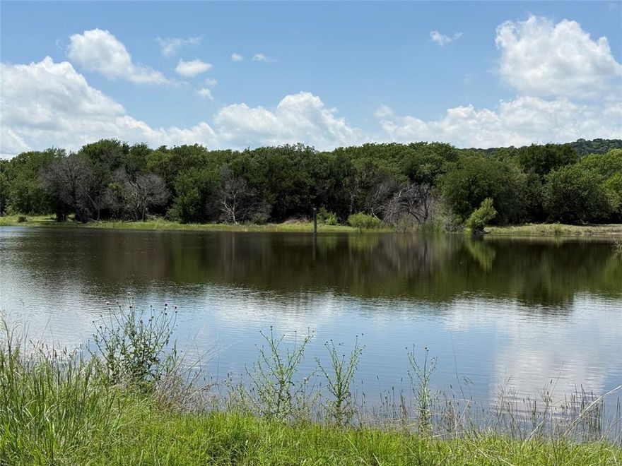 This is a private parcel setting at the base of Comanche Peak.  It is zoned agricultural use, outside the city limits.  No HOA.  This buildable site has incredible potential with the mountain views, seculuded, wooded, and cleared areas on this parcel.  A large tank enhances the beauty of this site.  The 3.2 acre lake has blue heron, geese, ducks, red birds, fish, and lots of wildlife.  There is a natural gas pad approximately 2 acres.  A pipeline runs along the road to the pad.  Please call the agent for details on the gas pad.  Restriction is no mobile homes. You may subdivide.  Also please see MLS listing 20935789 27.93 acres which borders this parcel.