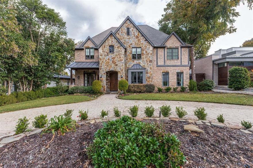 This refined residence in the heart of the Shore Crest area offers a blend of craftsmanship and thoughtfully designed indoor-outdoor living. An impressive two-story great room sets the tone with a stone fireplace, exposed beams, and iron-accented balconies overlooking the space. Sunlit windows and natural finishes create an inviting atmosphere that elevates both everyday living and entertaining. Arched openings lead into the gourmet kitchen, where Viking appliances, dual islands, abundant cabinetry, and a generous walk-in pantry support effortless cooking and hosting. A butler’s pantry conveniently connects the kitchen to the formal dining room for ease of entertaining, while a wine room with wrought-iron door detailing adds a striking architectural focal point. The main level also includes a private guest suite and a dedicated study enriched with custom millwork and wood-beamed ceilings. Upstairs, the serene primary suite offers a spacious sitting area and a beautifully updated, spa-inspired bath completed in 2024. The bathroom showcases an oversized floating vanity, a freestanding soaking tub, a walk-through shower, and dual walk-in closets. A media room, a game room with a vaulted wood-plank ceiling and refreshment bar, and two additional ensuite bedrooms complete the upper level and provide outstanding flexibility. Outdoor living is designed for year-round enjoyment. A covered stone patio includes a striking outdoor fireplace and a remote-controlled screened enclosure that can be raised or lowered with ease, overlooking the heated saltwater pool and spa to create a private retreat. A built-in outdoor kitchen with grill, refrigerator, and prep space enhances livability. Additional features include a wet bar, extensive storage, sound-system wiring inside and out, custom lighting, and a rear-entry garage. Set within minutes of Dallas’ best dining and shopping, Love Field, parks, and connecting trails.