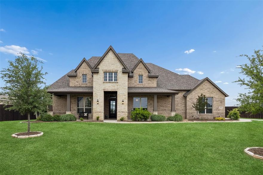 Stunning John Houston custom 4-bedroom, 3-bath home in Waxahachie, set on a beautifully maintained 1-acre lot in a quiet neighborhood in Midlothian ISD. From the moment you arrive, you’re welcomed by a sense of warmth, thoughtful design, and exceptional care throughout. This standout property offers a light-filled interior with high ceilings, tall doors, and durable LVP flooring that enhances both style and function. The spacious living room serves as the heart of the home, filled with natural light and designed for both everyday living and entertaining. It flows seamlessly into the impressive eat-in kitchen, complete with a large island with seating, built-in appliances, pantry, decorative lighting, and a bright breakfast room overlooking the backyard. The expansive dining area upgrade allows comfortable seating for 8–10. The serene primary suite provides a relaxing retreat, featuring a spa-inspired ensuite bath with dual sinks, separate vanities, a soaking tub, separate shower, and a generous walk-in closet. A guest bedroom with its own ensuite bath and walk-in closet offers added privacy and flexibility. Additional bedrooms are well-sized and complemented by a full bath. A dedicated home office creates an ideal space for remote work or creative pursuits. Don’t miss the upstairs space that adds valuable versatility, perfect for a game room, media space, or fitness area, along with convenient walk-in attic storage. Outdoors, extensive landscaping enhancements shine with mature trees, manicured grounds, and thoughtfully designed garden beds. The backyard retreat includes a pergola, tranquil water feature, and inviting spaces to relax or gather. Additional highlights include epoxy garage flooring and meticulous upkeep throughout. This property presents a rare opportunity to enjoy space, comfort, and refined living—ready for you to make it your own. 3D tour is available online!