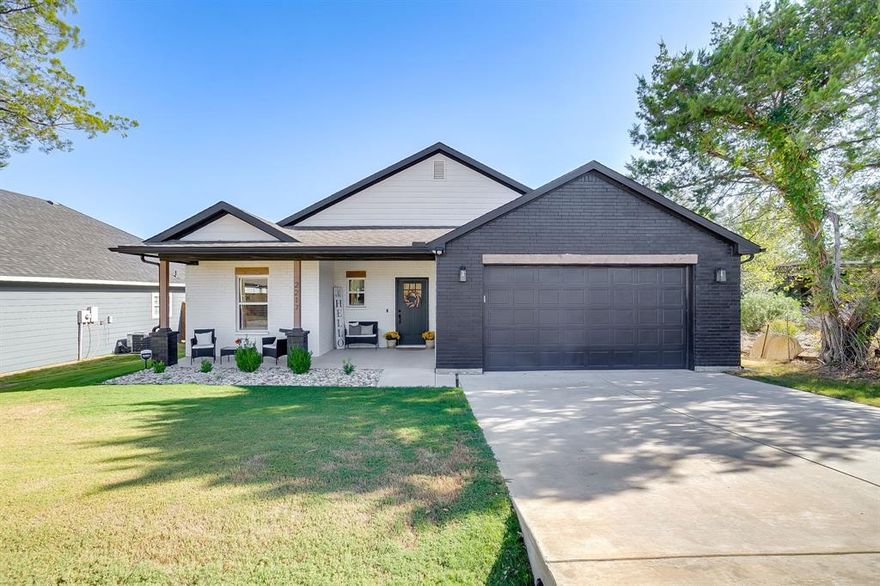 Beautifully upgraded, move-in ready, and designed for everyday living—welcome to Canyon Creek on Granbury Lake. For added ease, furnishings can be included—making your move simple, comfortable, and truly turnkey if desired. This stunning 3-bedroom, 2-bath home with a dedicated office offers 1,619 sq ft of thoughtfully designed space in a peaceful gated waterfront community. The open-concept layout is filled with natural light and features a stylish kitchen with stainless steel appliances, decorative lighting, and a cozy dining nook that flows seamlessly into the living area with an electric fireplace. Contemporary paint tones and clean, modern finishes create a warm yet elevated feel throughout. This home stands out with thoughtful upgrades already in place—built-in shelving in the laundry room and primary closet, walk-in closets in every bedroom, and a built-in doggie door for added convenience. Step outside to a backyard that truly sets this home apart. Enjoy an extended 20’ x 10’ patio, a covered pergola with fan, and built-in shades—perfect for relaxing or entertaining. With no neighbors directly behind or in front, you’ll love the added privacy and peaceful setting. The exterior is complete with gutters, a sprinkler system, full sod, and beautifully established landscaping, along with a charming front porch perfect for morning coffee or evening relaxation. Located in Canyon Creek, residents enjoy 24-hour staffed gated entry, lake access, two boat ramps, a fishing dock, two swimming pools, playgrounds, and courts for pickleball, tennis, and basketball. A rare opportunity to own a home with comfort, privacy, and upgrades already in place—ready for you to enjoy from day one.