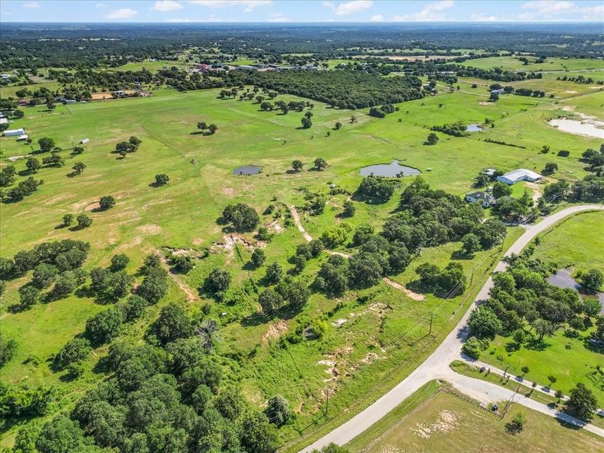 This rare 40.5-acre unrestricted acreage is AG exempt and offers limitless possibilities!  Ideal for hay production, livestock, equestrian facilities, or a custom home estate. With approximately 600 ft of road frontage, the property is cross-fenced into two pastures, includes two stock tanks, and features lush coastal Bermuda grass (80+ bales per cut) over sandy loam soil mixed with mature oaks. The property also supports an abundance of wildlife, including deer, adding to its natural beauty and recreational appeal.  Utilities are in place- electricity & septic, so you can build immediately or hook up an RV. Mineral rights are negotiable. Located less than 25 minutes to Weatherford and under an hour to Fort Worth, this Parker County gem borders a 12-acre tract (see MLS 20933995). A rare chance to own a versatile, unrestricted rural retreat with scenic views and investment potential.

Want a house already on land? These 40 acres borders another 12-acre property that is for sale. See MLS listing 20933995.