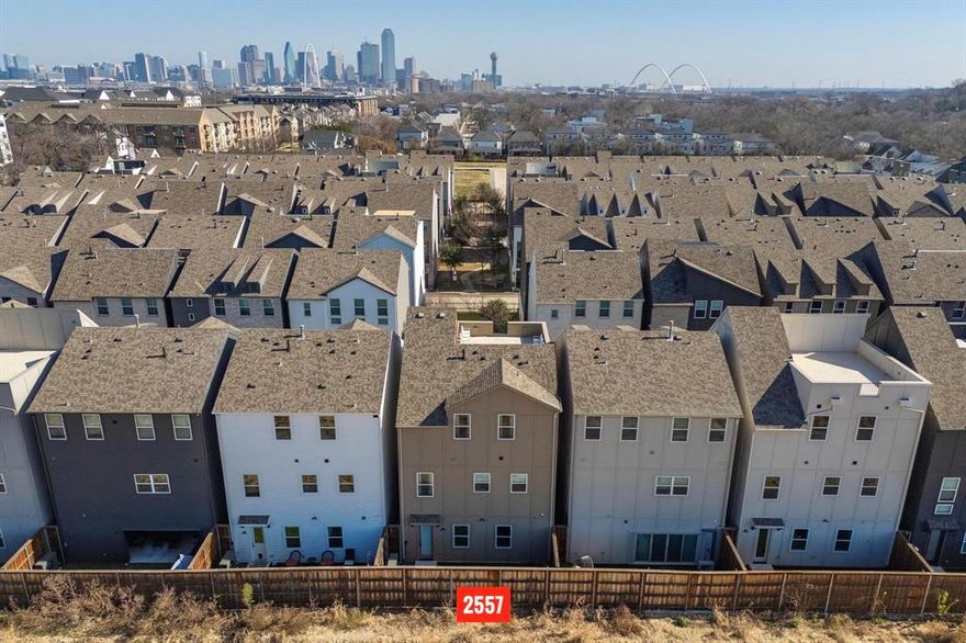 Don’t miss this highly versatile floor plan spanning 3 stories & multiple private outdoor spaces, including a huge rooftop deck with stunning skyline views! Built in 2022, impeccably maintained & thoughtfully updated. This like-new home boasts amazing natural light & stylish finishes throughout, with high ceilings & an open main floor that seamlessly blends living & dining spaces. Gorgeous gourmet kitchen equipped with a large island, pantry & SS appliances including a Samsung smart refrigerator, gas range & vented hood. Double doors off the living room open to a private covered balcony with park views! Laundry is conveniently located upstairs between both bedrooms (each with ensuite baths). Primary suite features dual sinks, a huge walk-in shower & tons of storage space. Remaining bed & bath on first floor could be used as an in-law suite, office or media room (tons of flexibility!) with direct access to a private side yard & the 2-car garage. Custom features include wood panelling installed in the primary, living room & half bath, custom kitchen cabinet hardware, sink in half bath + bathroom mirrors on first & second floors. Other updates include a sliding glass door installed for the bath tub & all toilets replaced. SoHo Square residents enjoy a plethora of neighborhood amenities, with access to a chic community lounge (complete with a kitchen), fitness center, pool + spa, bowling alley, golf simulator & game room. Don’t miss this stylish 3-story home in a convenient Dallas location, close to major highways, schools & parks, minutes to Downtown Dallas!