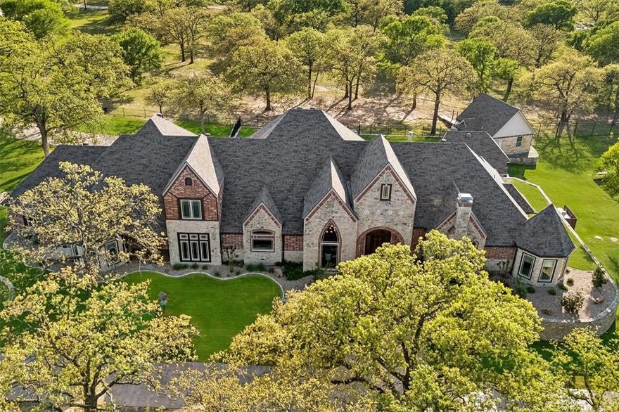 Tucked behind private gates on 18.5 acres, this distinguished Granbury estate delivers a rare combination of luxury living and ranch life—all just minutes from the town square. The custom stone residence spans over 7,300 square feet and was designed for both everyday comfort and large-scale entertaining. Expansive living areas, a dedicated media room, and a game room create a seamless flow, while the outdoor spaces—complete with a resort-style pool and outdoor kitchen—extend the living experience beyond the home. Equestrian improvements are equally compelling, featuring a well-designed barn with 14 stalls, multiple fenced pastures, and loafing sheds. A separate foreman’s home and guest house offer versatility for staff, guests, or multigenerational living. Recent updates and thoughtful upgrades throughout the property include new windows, updated appliances, quartz surfaces, wood flooring, and a fully integrated security system. A reinforced safe room provides added peace of mind. The land itself is both beautiful and functional, with a pond, mature hardwoods, and carefully maintained, low-maintenance landscaping. A solar power system with Tesla battery backup adds a forward-thinking element of efficiency and sustainability. Additional features include an oversized shop, fiber optic internet, and a private circular drive that enhances both convenience and curb appeal. A property of this caliber—offering privacy, usability, and proximity to Granbury—is increasingly hard to find.