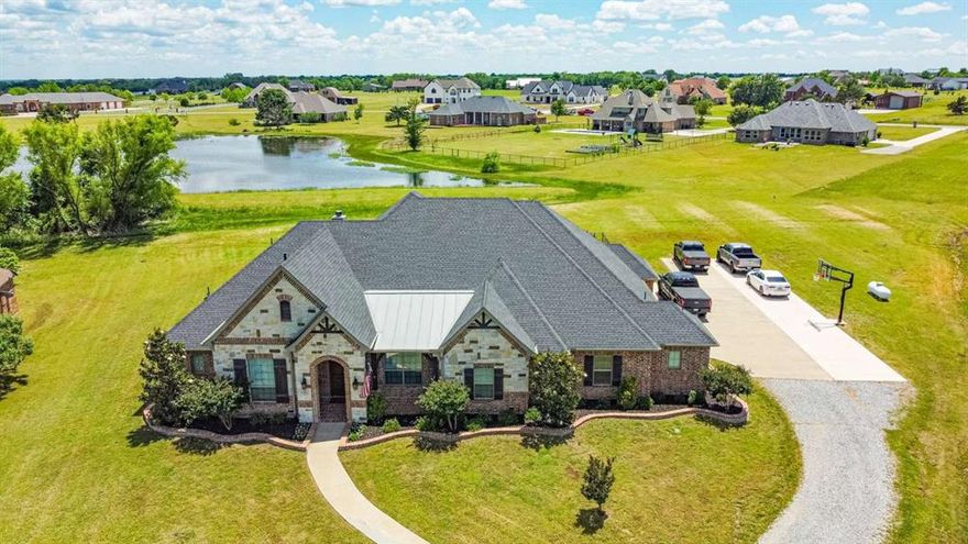 Welcome to this stunning 4-bedroom, 3.5-bath home nestled on a peaceful cul-de-sac in Hidden Lakes Ranch! This single-story gem sits on a 1.09-acre lot with a tranquil water view, offering 3,099 sq. ft. of living space and 4,780 sq. ft. total under roof. Highlights include an oversized 3-car garage, a whole-house AquaSana water purification system, energy-efficient LED lighting, and gorgeous hand-scraped hardwood floors. The kitchen features a GE Monogram 6-burner cooktop with pot filler, professional vent hood, oversized granite island, knotty alder cabinetry with soft close doors, over-under cabinet lighting, and huge walk-in pantry. The master suite boasts a spacious 12x10 walk-in closet and a luxurious bathroom with heated travertine floors, large soaking tub for two, and large shower with rain head. Additional features include a home office, living room with a gas log stone hearth fireplace, indoor tornado shelter-safe room, 40' RV parking pad, 20x30 walk-up spray foam insulated attic for extra storage, and covered patio with an outdoor fireplace and propane hookup for a future outdoor kitchen. Too many unique features to list! Please ask for the complete detailed list and come see this amazing property located in Gunter ISD!