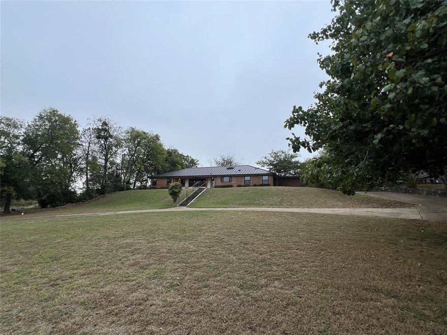 Available near the end of FEBRUARY: This stylish completely updated mid century ranch style home sits atop a hill on almost an acre,  just minutes from down town Fort Worth and the Stockyards. Fully furnished short term rental is perfect for corporate housing and insurance claims. Set back from the street so you can enjoy the view from the covered front porch, you can enjoy a bit of solitude while being right in the city. Custom built from the slab up with new everything in 2022. New custom skylights and new tilt-in easy clean windows for natural light throughout, quartz countertops, farmhouse double sink, tons of storage, custom built wood cabinets and pantry, and Spanish Saltillo tile. The primary has 2 walk in custom closets, and a lovely bathroom with dual sinks, white quartz, a walk in shower & separate garden tub. The other two rooms share a large Jack and Jill set up with custom closets. Tons of space in the living, dining, and kitchen areas, and a cozy fireplace in the dining room on almost an acre lot. Tenant is responsible for utilities. Lease term is negotiable. Month to month, short term, mid length, and fully furnished! Casa amueblada en alquiler!