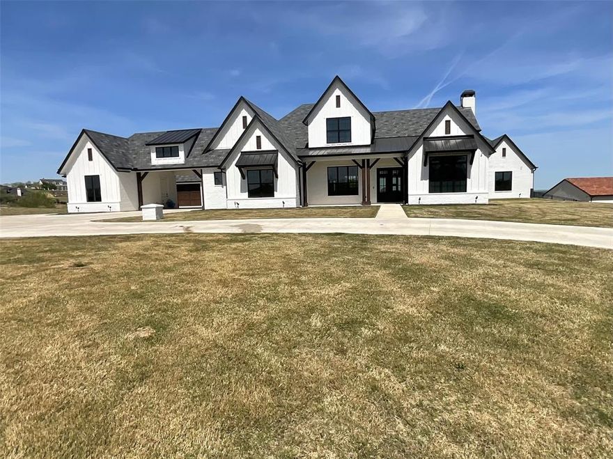 Welcome to an extraordinary estate in the gated La Madera neighborhood, where luxury living meets wide open Texas skies. Situated on 2.68 acres, this stunning 5,000 square foot home offers 5 bedrooms, 3 full baths, and 2 half baths, thoughtfully designed with both elegance and functionality in mind. From the moment you arrive, the curb appeal makes a statement with its grand presence and expansive driveway offering ample parking for the car enthusiast. Inside, the open floor plan is filled with natural light and showcases exceptional attention to detail, including ceiling beams, custom built ins, and a beautiful stone fireplace anchoring the main living room. The chef’s kitchen is truly the heart of the home, featuring an oversized island, stainless steel appliances, built in refrigerator, double ovens, gas cooktop, a waterline and plumbing for ice maker or wine cooler, butlers pantry, and a spacious walk in pantry. Entertain effortlessly with seamless flow into the main living and dining areas. The first floor primary suite is a private retreat with vaulted ceilings, an oversized walk in closet, and a luxurious spa like bathroom complete with separate vanities, a soaking tub, large tiled walk in shower, and dedicated makeup vanity. A first floor guest suite provides comfort and privacy for visitors. Designed for both relaxation and recreation, this home offers three living spaceson the first floor the gameroom features a wet bar, beverage fridge, a dedicated study, exercise room, and media room. Upstairs, you’ll find two additional bedrooms, each with its own ensuite baths, along with a spacious gameroom and balcony overlooking the resort style pool. Step outside to your private backyard oasis where the pool and expansive patio area create the perfect setting for entertaining or enjoying peaceful sunsets over the acreage.