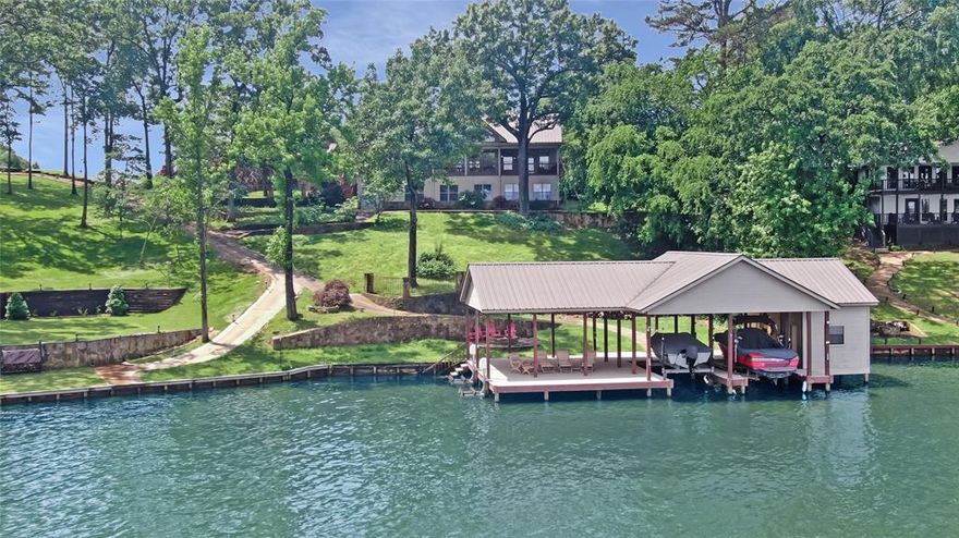 Experience the pinnacle of lakeside living with this extraordinary partially furnished 5-bedroom, 5-bathroom estate spanning 5,822 square feet of refined comfort. Perfectly positioned on the coveted main body of the lake, this property offers deep water access and expansive shoreline—an ideal setting for boating, swimming, and soaking up panoramic views year-round. Freshly painted and professionally landscaped, the main residence exudes warmth and timeless elegance. Step inside to discover soaring vaulted ceilings, walls of windows, and abundant natural light that showcase breathtaking lake vistas. The open-concept living areas and oversized kitchen are tailor-made for entertaining, while each bedroom is a private sanctuary, complete with walk-in closets. Downstairs, a cozy family room, additional private bedrooms, and an enclosed porch provide versatile space—perfect for a game room, home gym, or kids’ playroom. The living experience seamlessly extends outdoors, where beautifully manicured grounds, expansive patios, and your own private aluminum-decked boat dock await. Designed for both function and relaxation, the dock features 2 boat slips, 2 large storage closets and a splinter-free, cool surface underfoot—ideal for sunny afternoons on the water or peaceful mornings with a cup of coffee. The property also includes an oversized, extra-deep 3-car garage with ample room for lake toys, tools, and even a golf cart. Just behind it, the fully appointed guest house offers a full kitchen, living area, bedroom, and laundry hook-ups—an ideal in-law suite or private quarters for visiting family and friends. Additional features include a state-of-the-art bug misting system installed on the main house, dock, and guest house for added comfort and convenience. This is more than a home…it’s a lifestyle. Don’t miss your opportunity to own one of the finest lakefront properties on Lake Cypress Springs.23 foot surf boat on the dock available for purchase in a separate transaction.