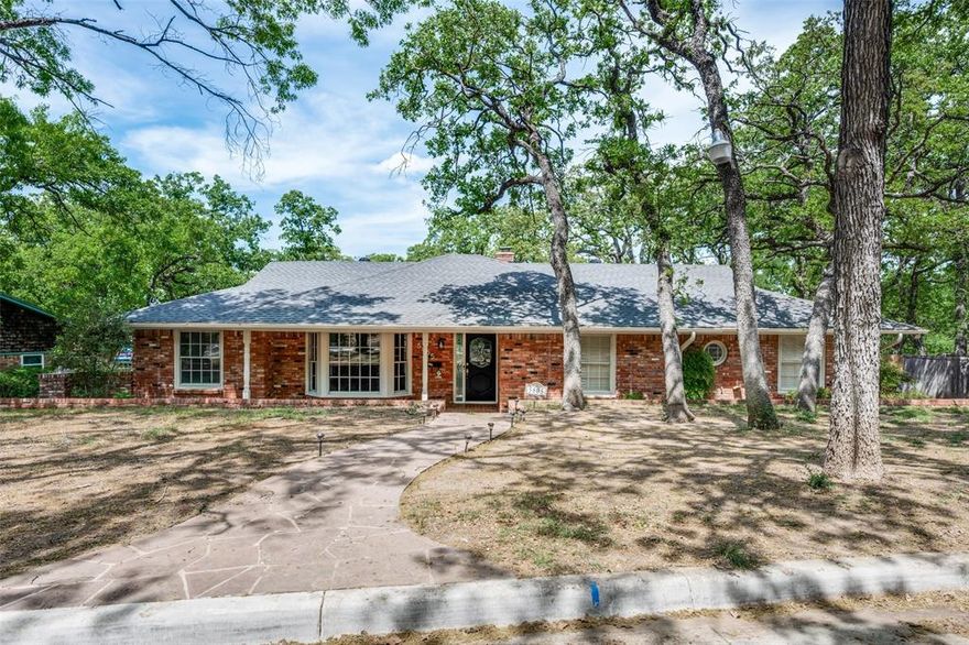 NEWLY RENOVATED OPEN FLOORPLAN!
A storybook wooded front yard welcomes you home to this fabulous 1-story design with 3 bedrooms, 2 full baths, private study (or formal dining) and 2-car garage. Entering off the foyer you'll find an expansive living room with bay window flowing into a family room featuring a cathedral ceiling with wood beams, massive stone fireplace and large picture window .A study or formal dining room is accented by barn doors, offering privacy for days working from home. Kitchen highlights include white painted cabinets, granite countertops, stainless steel appliances and subway tile backsplash. The main bedroom retreat includes double closets and private access to the renovated bathroom. The guest bedrooms  enjoy a jack & jill renovated second bath. All bedrooms include beautiful custom plantation shutter window treatments. Extra closets and storage in hallway, laundry room and two car garage in addition to a storage unit in yard. Entertaining will be unforgettable with a large backyard patio and heavily treed open space. Driveway with private iron gate access to rear yard. Easy freeway access to i30 and 820 and downtown Fort Worth. Walking distance to Eastern Hills Park and Oakland Park.