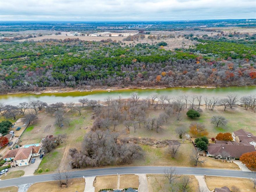 Nestled on nearly two acres with rare Brazos River frontage, this exceptional homesite offers a truly special opportunity to own one of the last riverfront properties of its kind within the prestigious, gated community of Pecan Plantation. The setting is peaceful and scenic, with sweeping water views, abundant wildlife, and the calming presence of the river creating a sense of serenity that is increasingly hard to find. This expansive lot provides ample space to design and build a custom home that takes full advantage of its natural surroundings while still enjoying all the conveniences of an established community. Pecan Plantation offers an unmatched lifestyle with amenities that include two golf courses, a private airstrip, full service marina with access to Lake Granbury, on site grocery store and gas station, multiple dining options, a clubhouse with hotel accommodations for guests, fitness center, pools, tennis courts, pickleball, walking trails, and a vibrant calendar of community events. Beyond the gates, residents enjoy all that Granbury has to offer, including the historic square, local dining, shopping, entertainment, and year round activities. Opportunities like this are incredibly rare and cannot be recreated, making this an ideal choice for those seeking a legacy property with river access, space, and an amenity rich lifestyle in one remarkable setting.