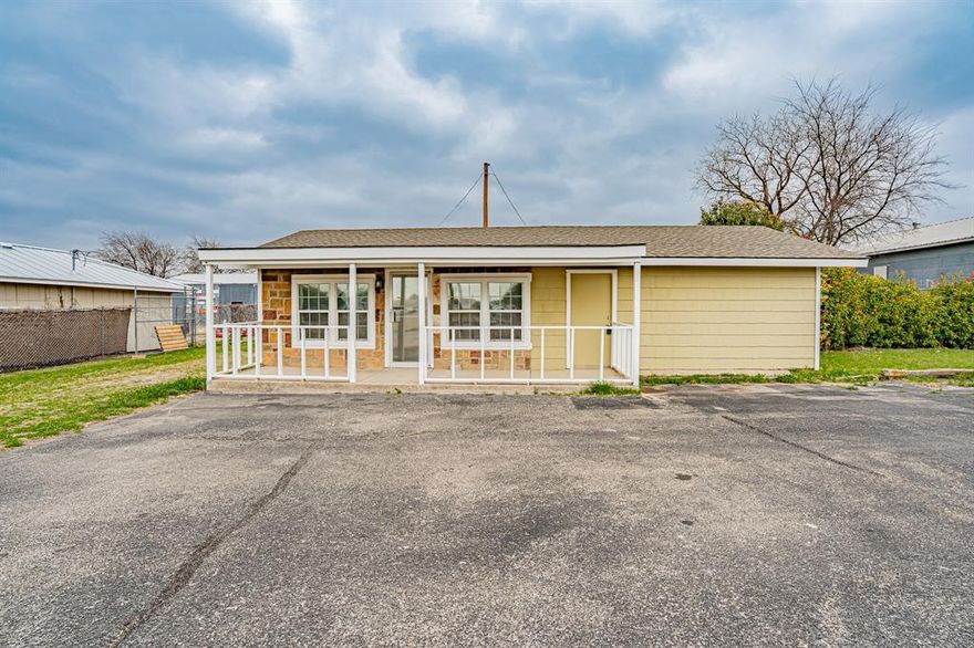 Great commercial building just a block off Hwy 377. Nicely updated office building and storage yard. A charming front porch welcomes you to work each day. Large main entry with plenty of room for a reception area, lobby and open desk space. Nice half bath off the main room. Three large private offices and an alcove perfect for a kitchenette. Zoned for heavy commercial but currently used as an office. Large yard in back and a two vehicle carport with side walls.  Outside painted in 2026. Rock facing and cement fiber siding. City water and septic. City sewer is available. Very tasteful office space.