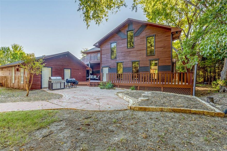 Set against the tranquil backdrop of Lake Lavon, this beautifully renovated waterfront retreat is more than a home—it’s a lifestyle. Thoughtfully designed with flexibility in mind, the home is divided into two wings, easily separated by interior door partitions: a private single-story 2-bedroom, 1-bath suite (original structure), and a two-story main residence addition (added circa 2002) featuring 4 ensuite bedrooms & 2 half baths. This one-of-a-kind property offers serenity, versatility, &  income potential in a beautifully reimagined package. Recent renovations include designer-updated kitchens with open shelving, custom cabinetry, and high-end appliances, as well as upgraded finishes throughout. Solar panels enhance energy efficiency, & a spa overlooking the lake elevates the outdoor experience. Whether you're seeking a peaceful primary residence, a multi-generational setup, or short-term rental options, this home checks every box. Multiple levels of decking create inviting spaces for relaxation & entertaining—sip your morning coffee with panoramic lake views, soak in the spa at sunset, or gather with guests on the covered patio. With direct lake access, natural surroundings, & intriguing architecture, this property offers a rare blend of comfort, function, and beauty—just outside the city, yet a world away from the hustle. Detached 2-car garage with extended approach provides plenty of parking space & workshop & toy storage.